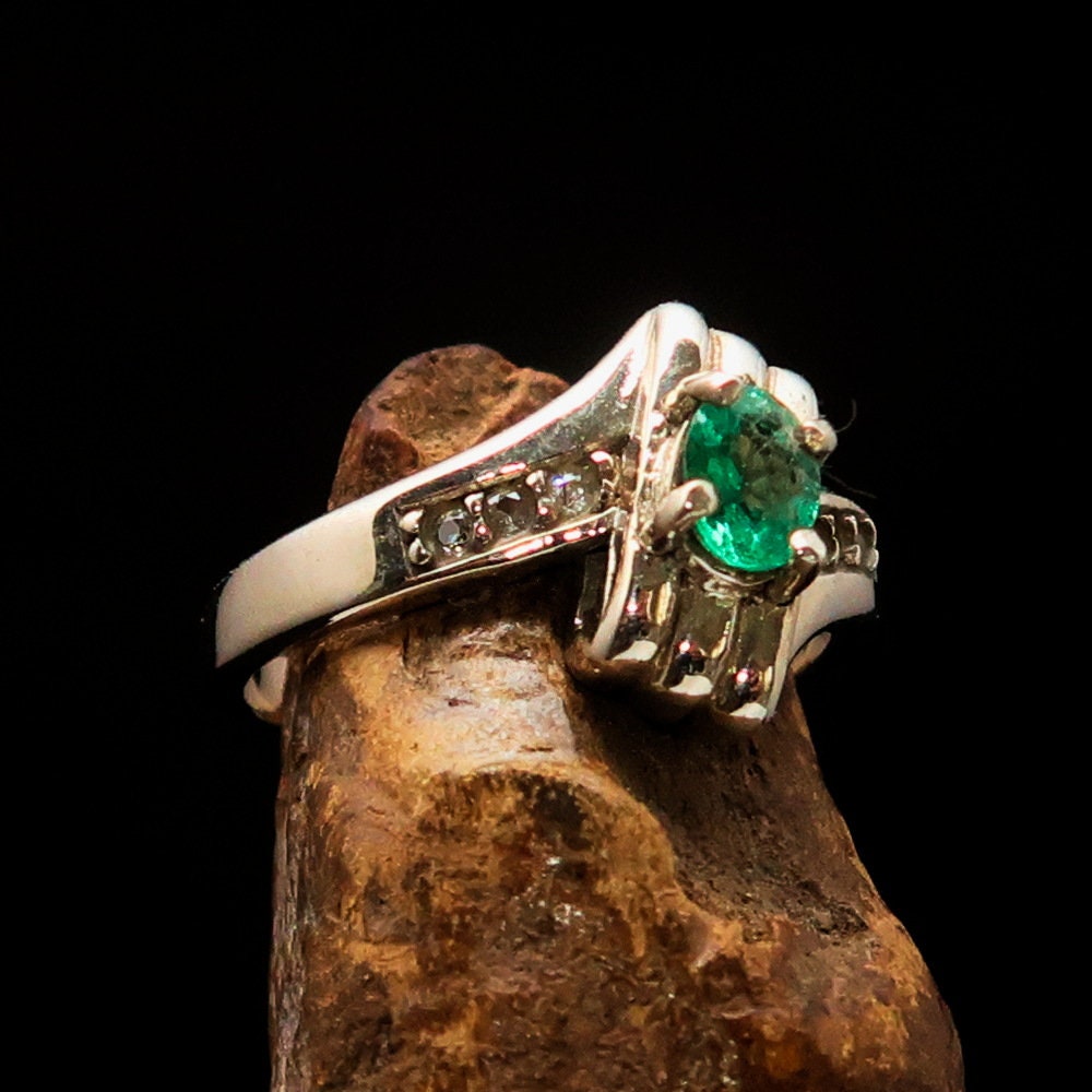 Handmade sterling silver emerald ring featuring an oval cut green emerald and six cubic zirconia stones, hallmarked 925.