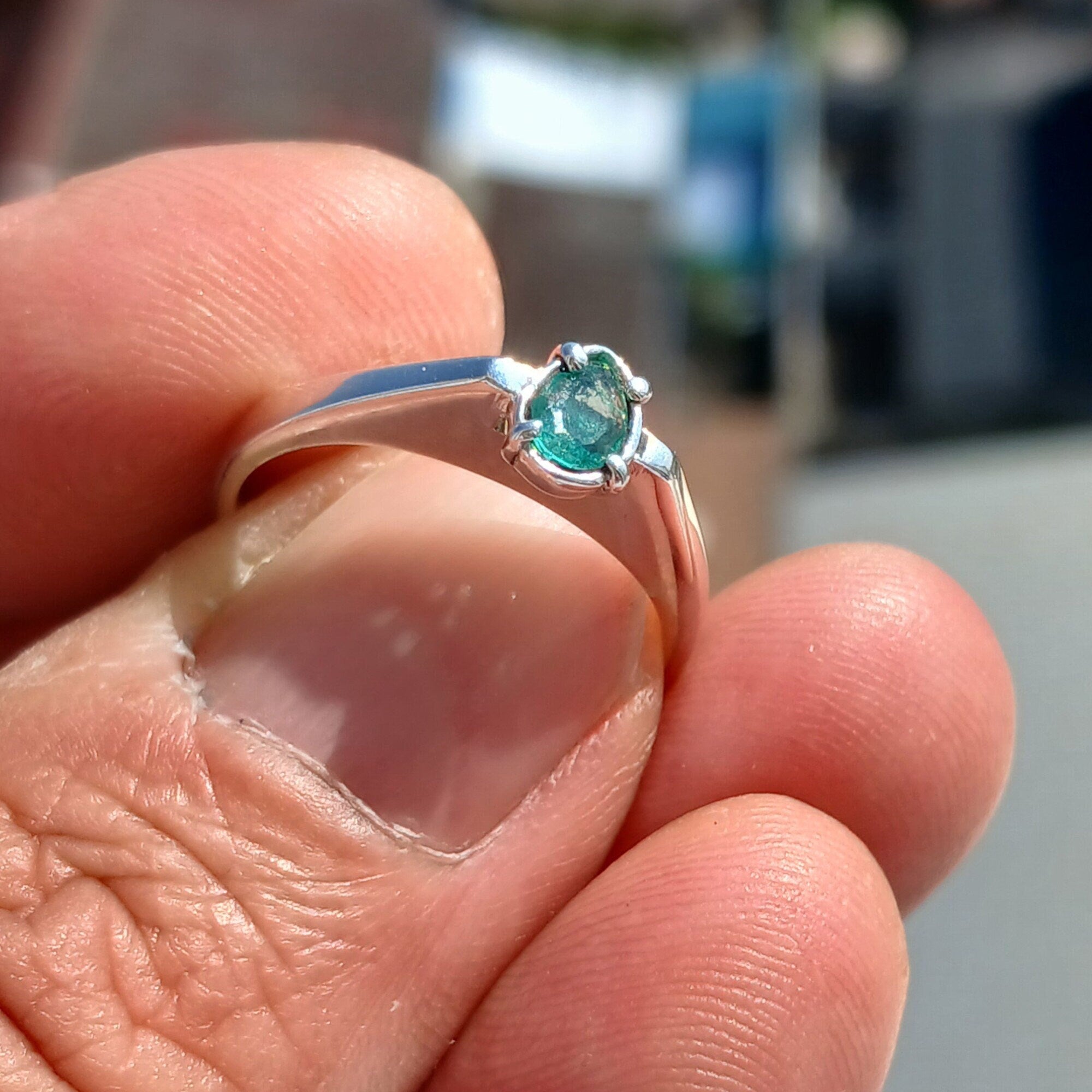 A stunning handmade sterling silver ring featuring a natural green pear-shaped emerald, polished to a high shine.