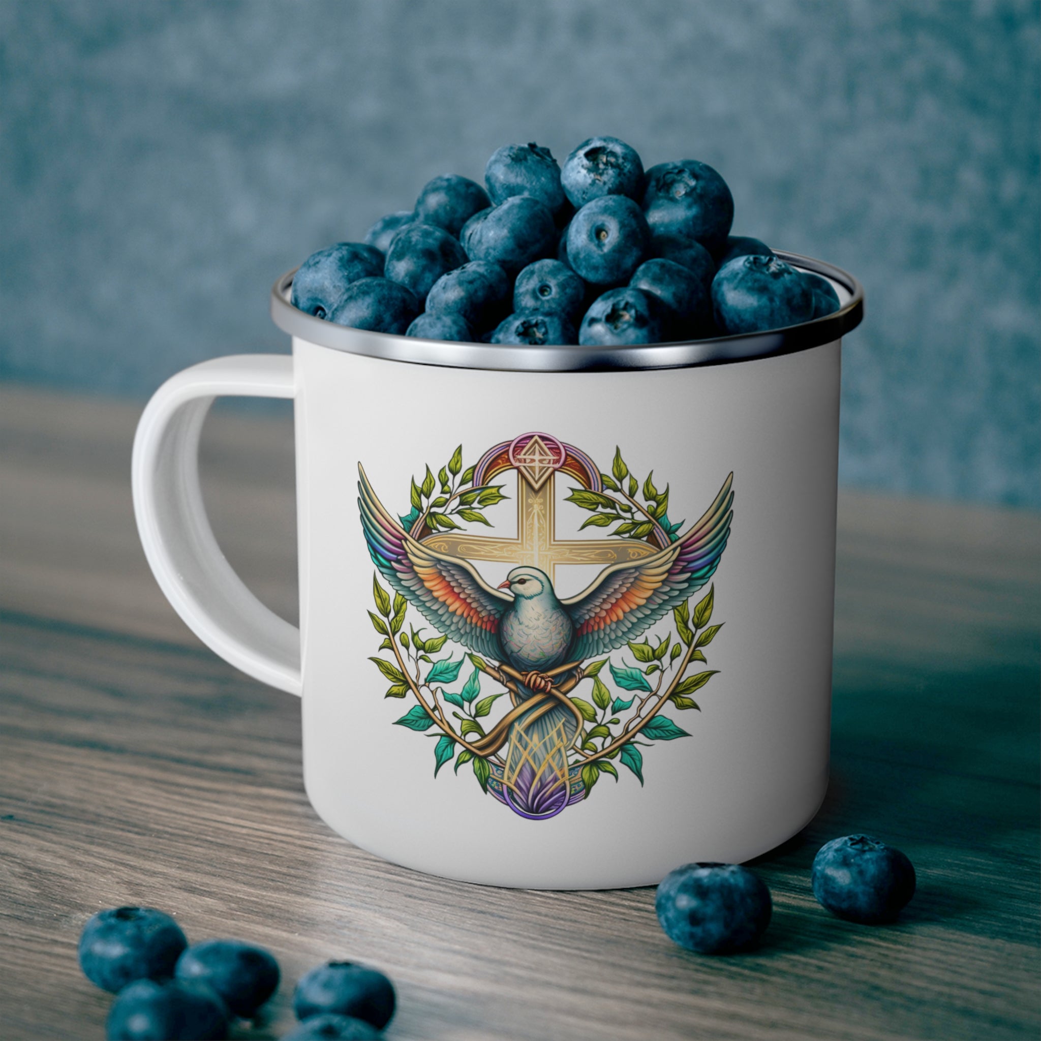 Blue green enamel camping mug featuring a multicolor dove floral illustration, perfect for outdoor activities.