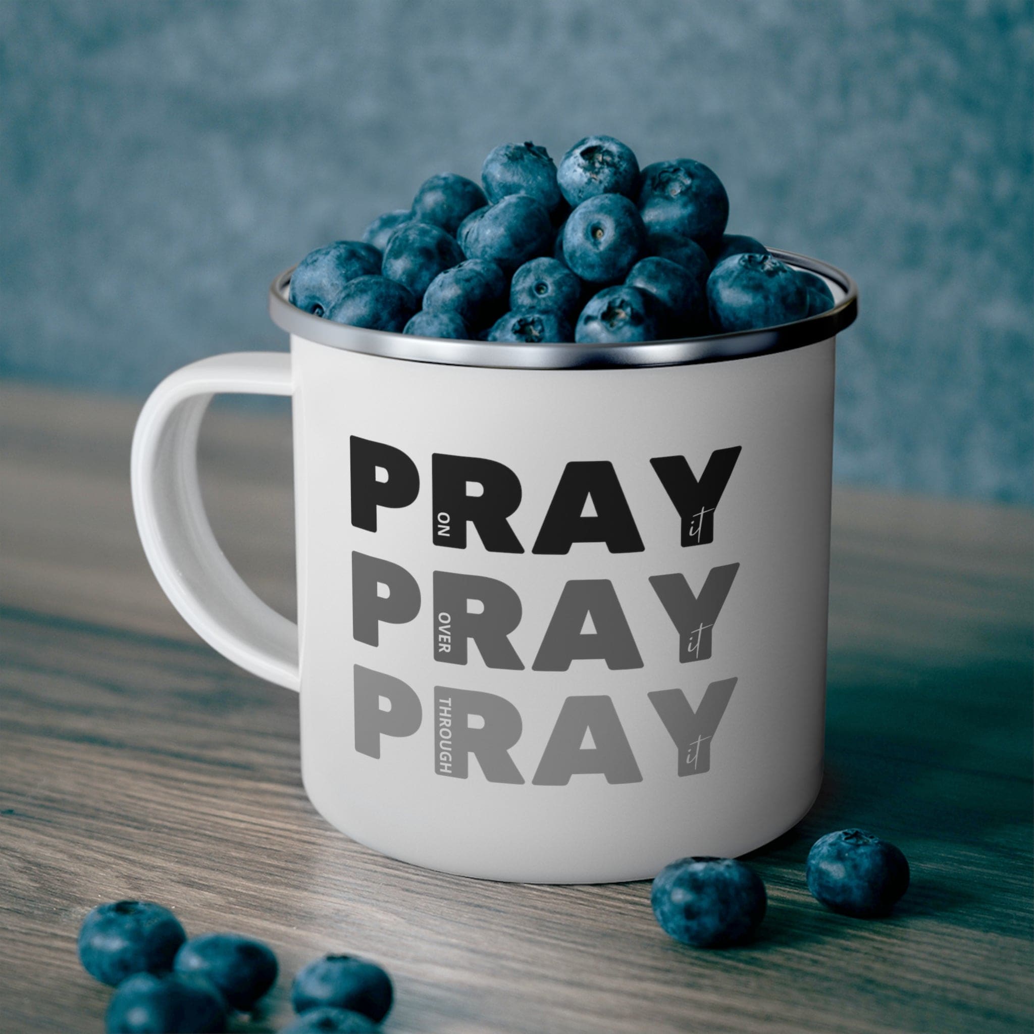 Durable enamel camping mug featuring a black illustration with the phrase 'Pray on it Over it Through it', perfect for outdoor and indoor use.