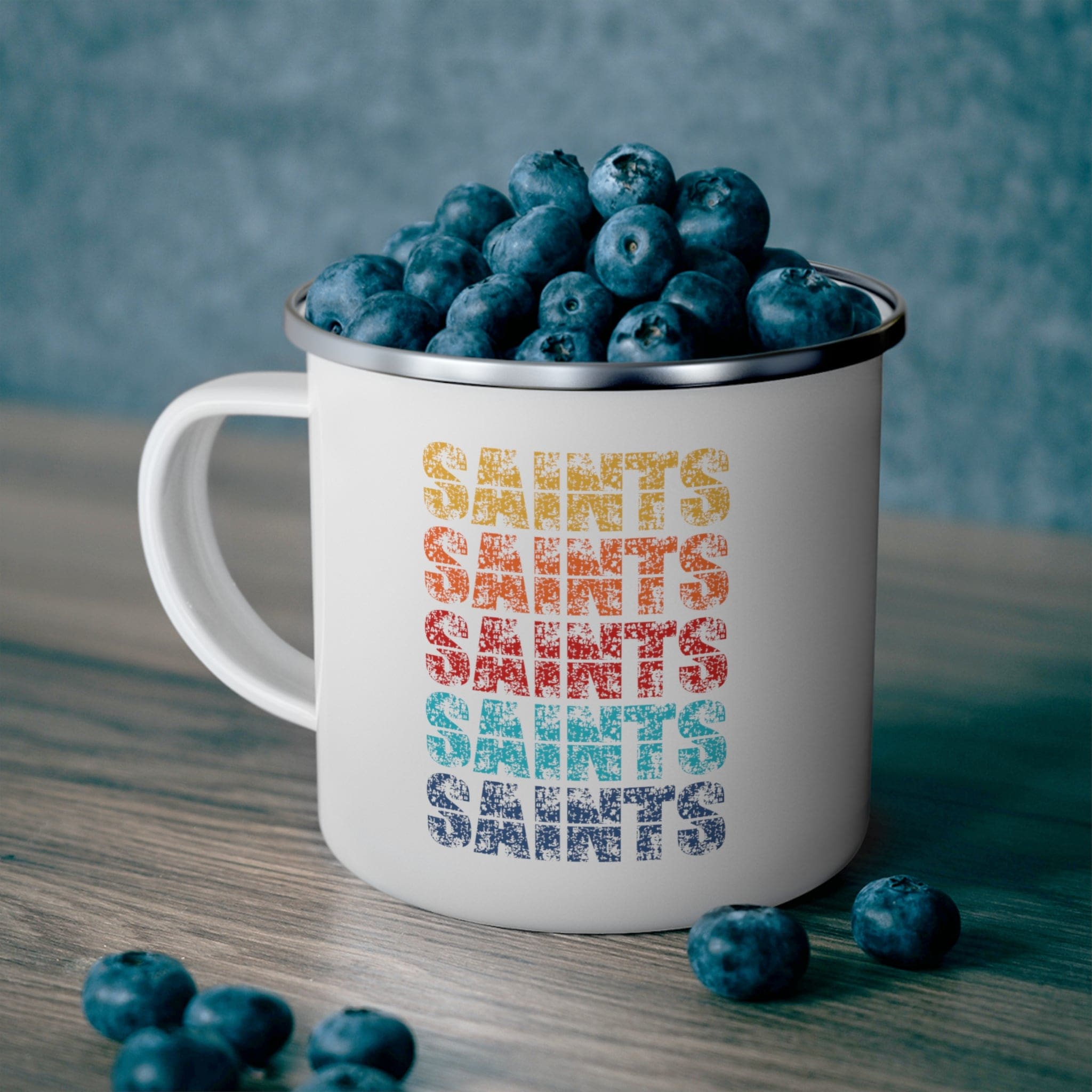 Colorful enamel camping mug featuring Saints art illustration, perfect for outdoor and indoor use.