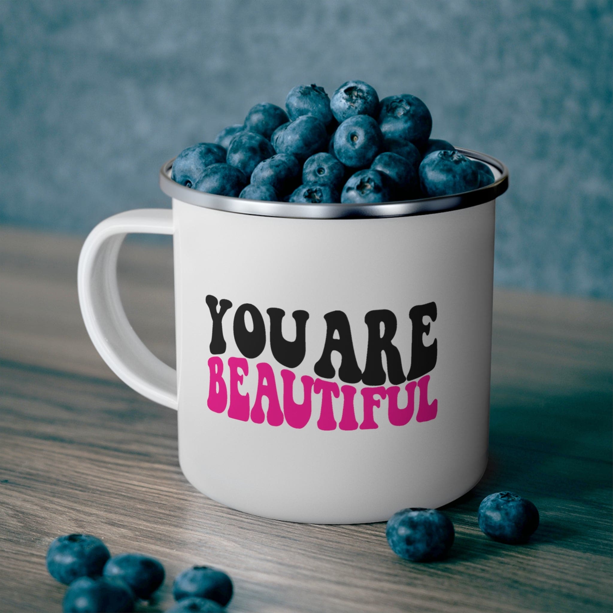 A stylish pink and black enamel camping mug with the affirmation 'you are beautiful' printed on it, perfect for outdoor and indoor use.