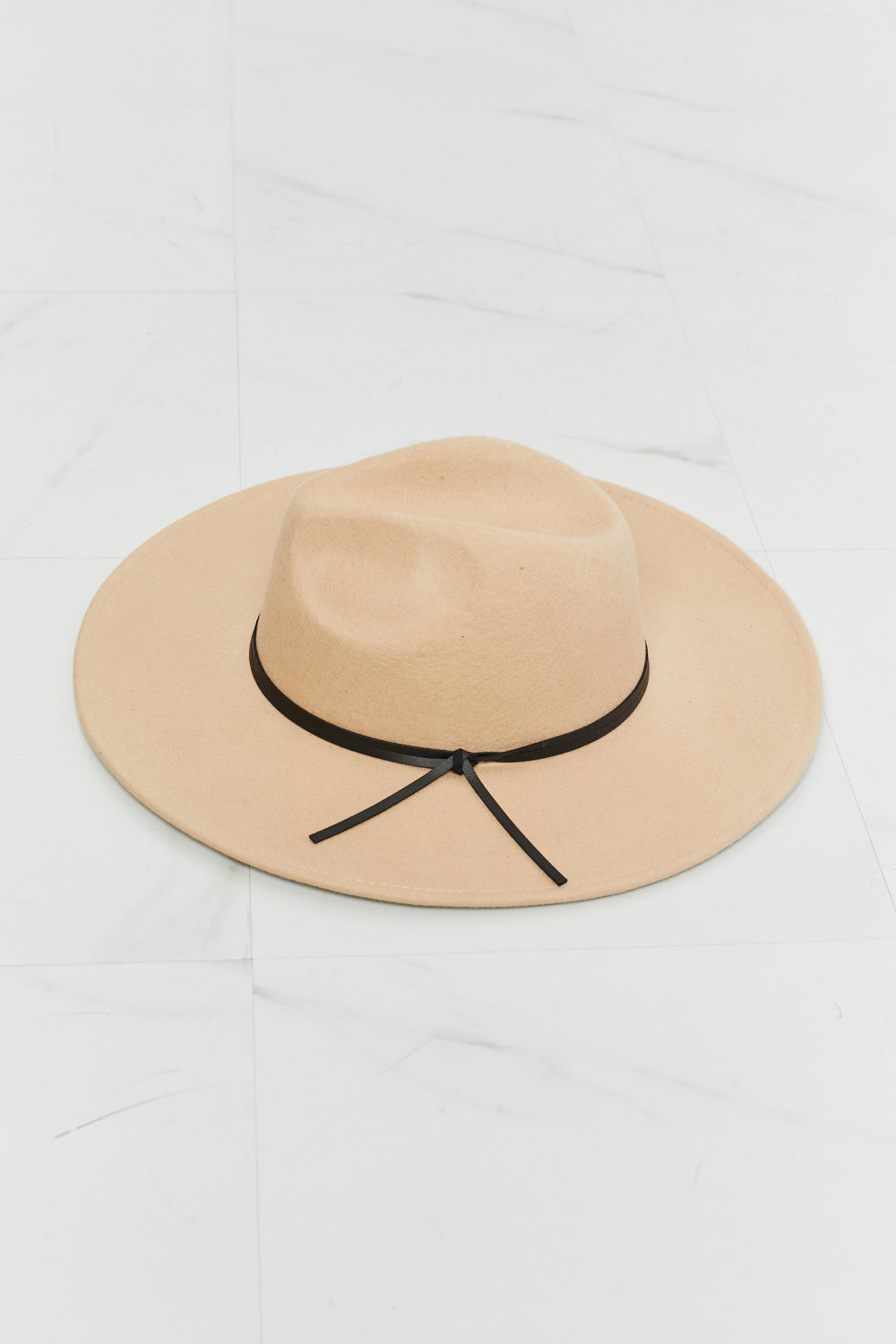 Fame Make It Work Fedora Hat in soft beige with black faux leather knot detailing, showcasing its elegant design and adjustable straps.