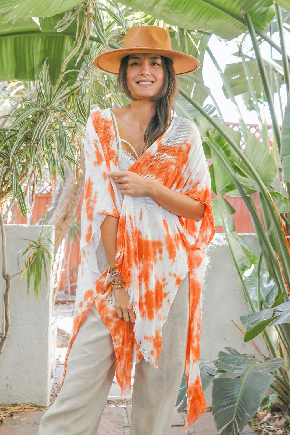 A colorful tie-dye kimono with vibrant patterns, perfect for festivals and warm weather, draped elegantly on a mannequin.