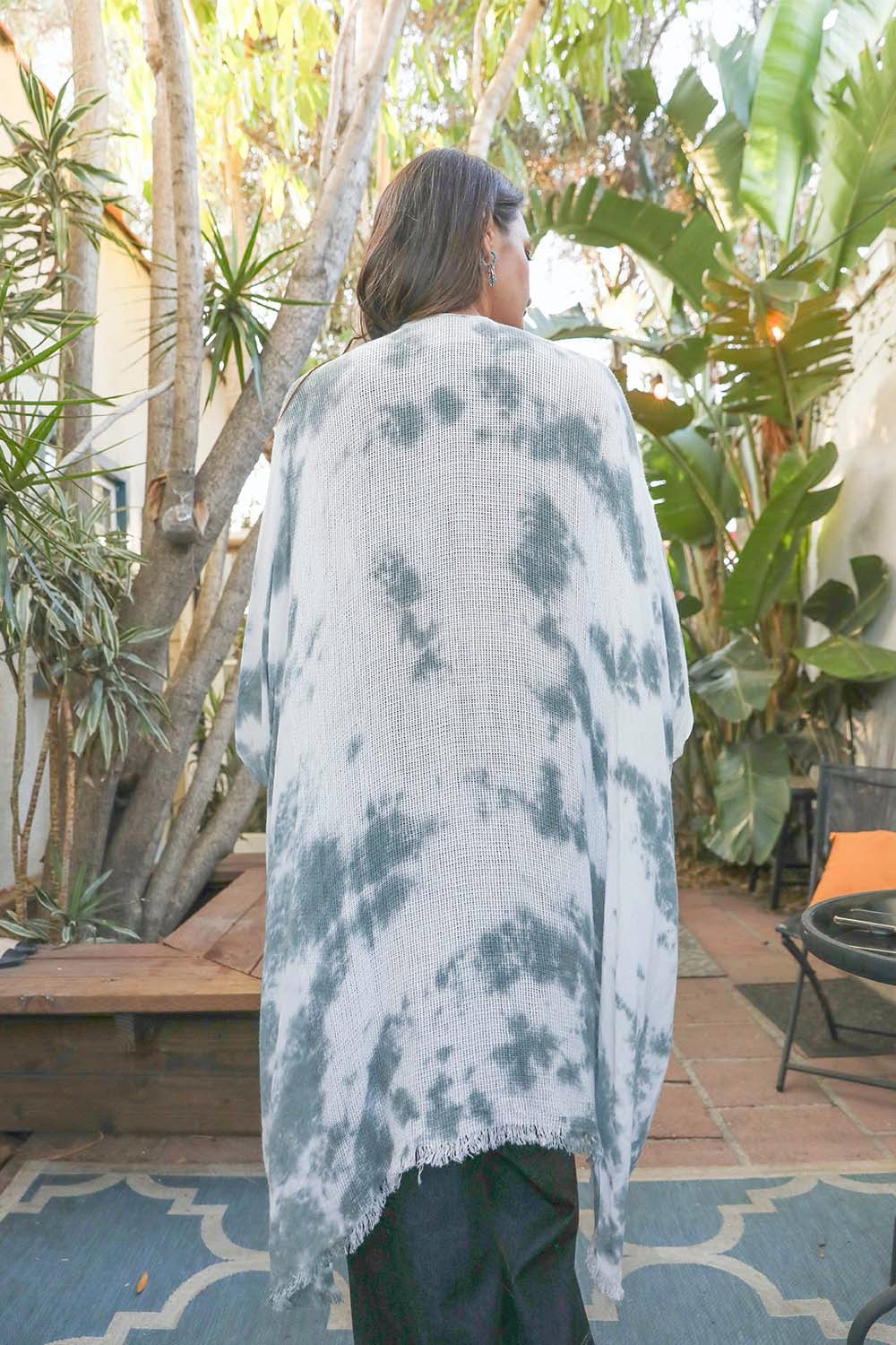 A colorful tie-dye kimono with vibrant patterns, perfect for festivals and warm weather, draped elegantly on a mannequin.