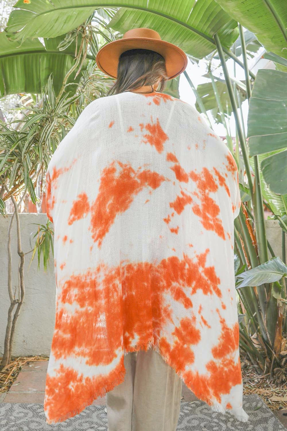 A colorful tie-dye kimono with vibrant patterns, perfect for festivals and warm weather, draped elegantly on a mannequin.