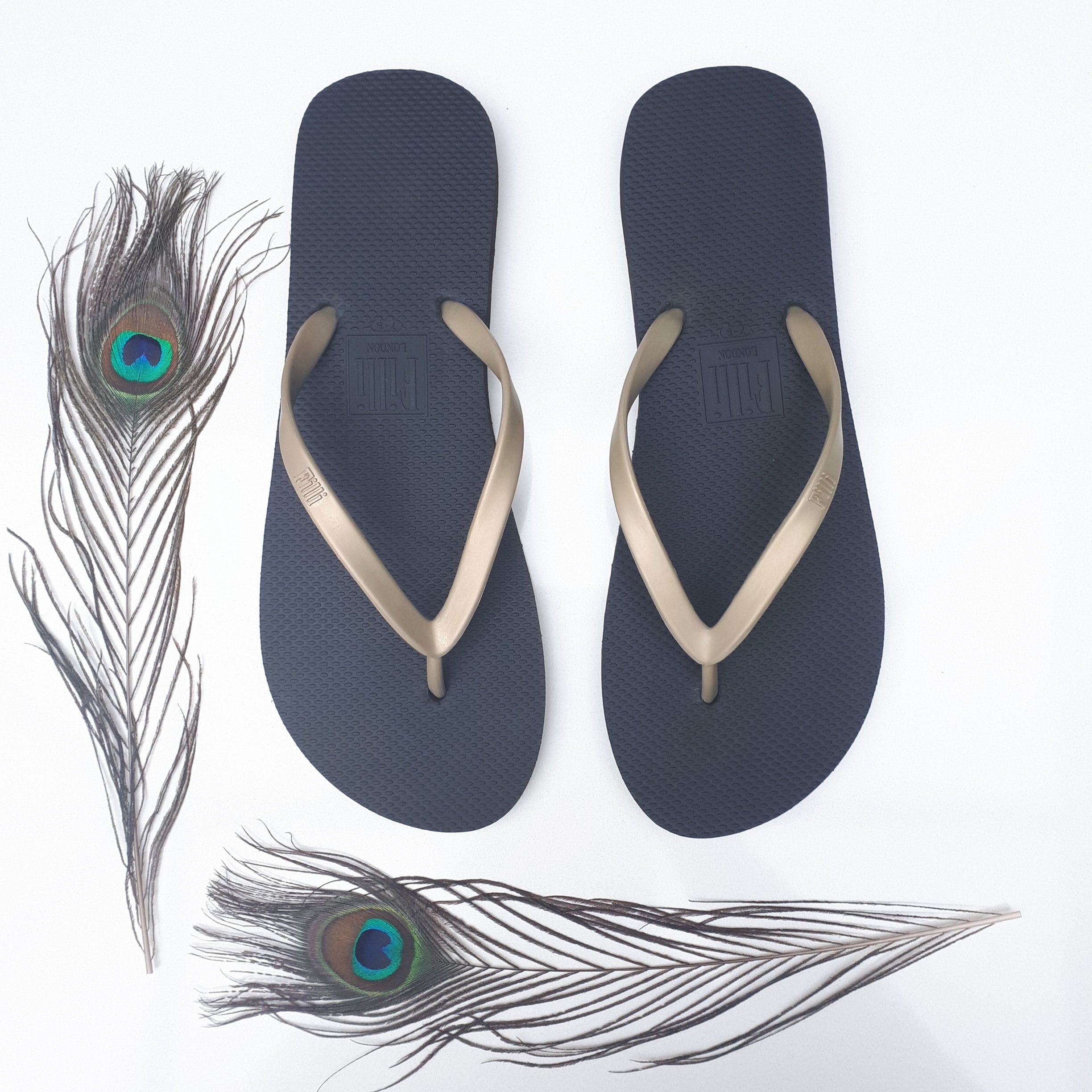 Filli London Naked Flip Flops in Gold on Black with embossed logo and rice pattern footbed.