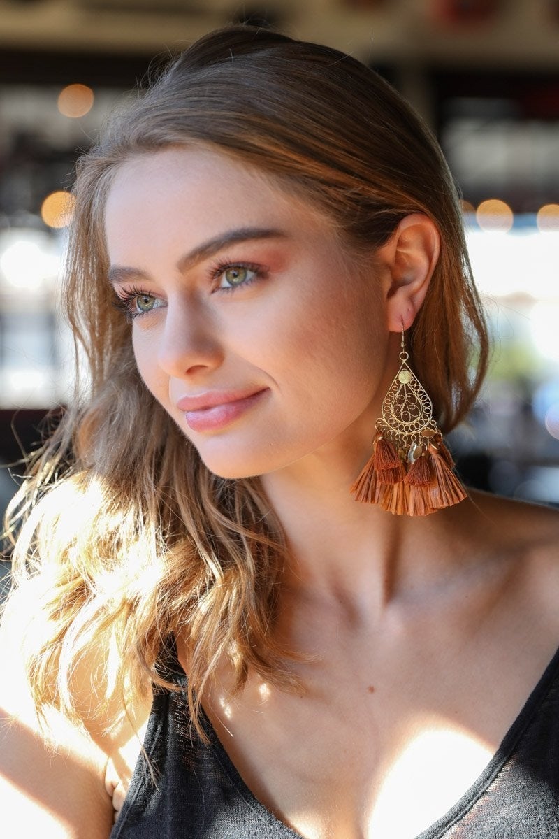 Elegant Filigree Raffia Tassel Earrings featuring intricate brass design and soft tassels, perfect for stylish accessorizing.