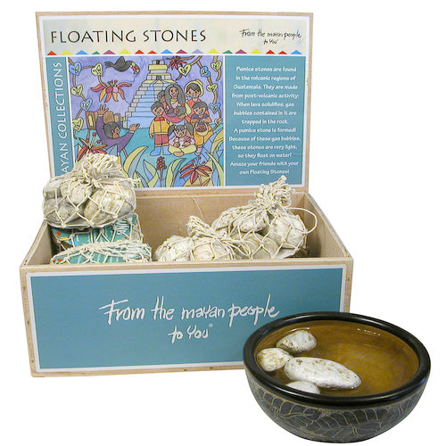 A collection of lightweight volcanic pumice stones floating in a decorative water bowl, showcasing their natural beauty and unique textures.