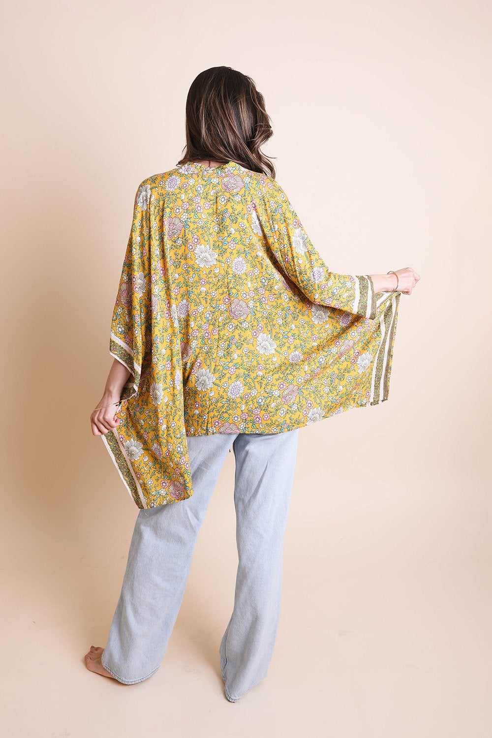 A lightweight floral front tie kimono wrap, perfect for summer outings, featuring vibrant colors and a flattering design.