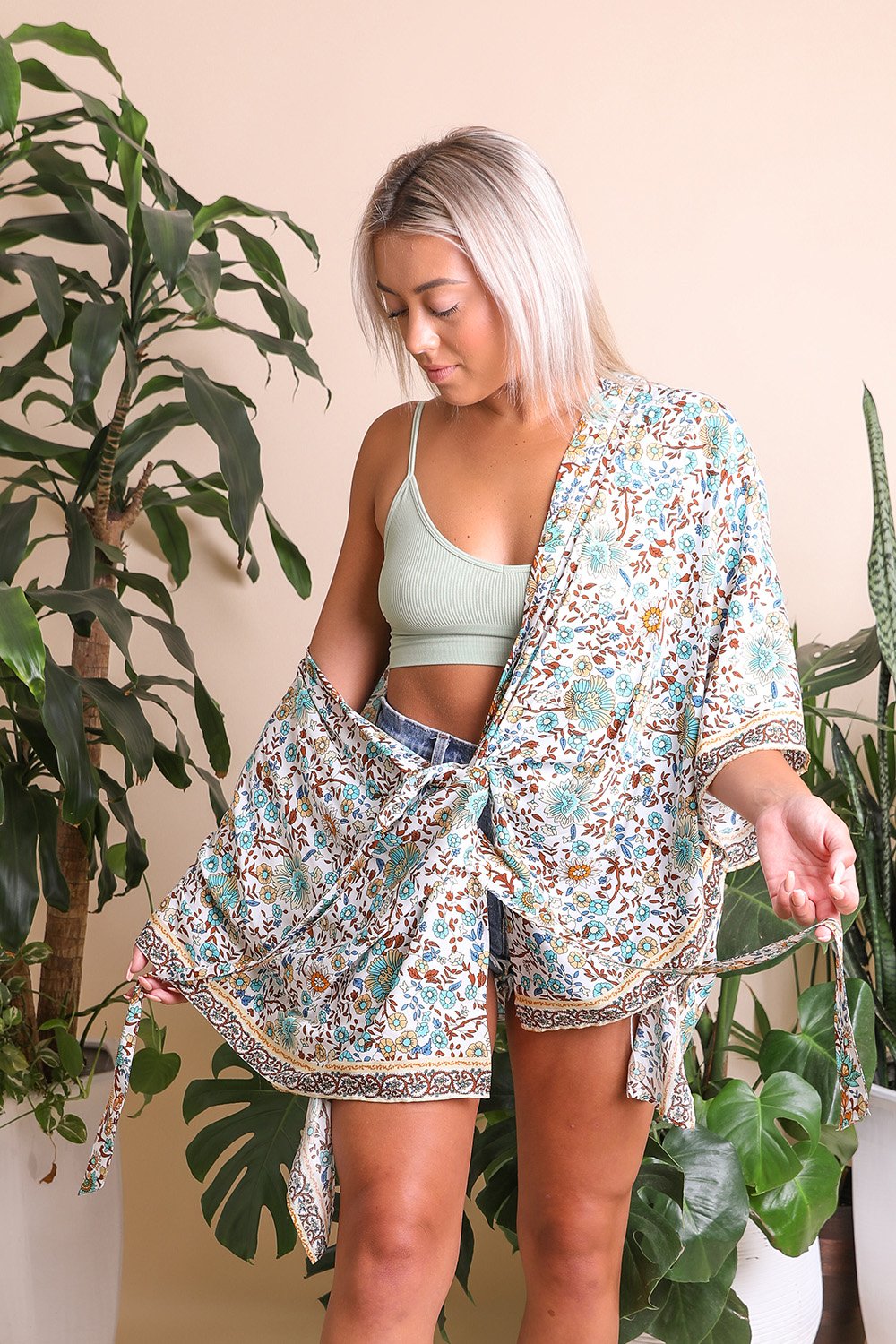 A lightweight floral front tie kimono wrap, perfect for summer outings, featuring vibrant colors and a flattering design.