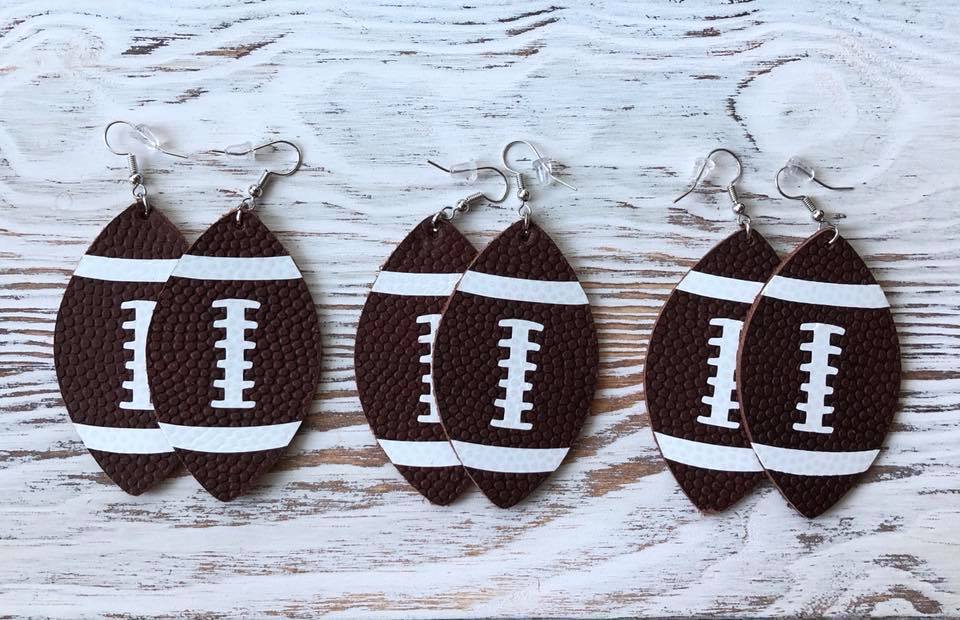 A pair of stylish football-shaped leather hang earrings, measuring 2.5 inches, showcasing a unique design perfect for sports enthusiasts.