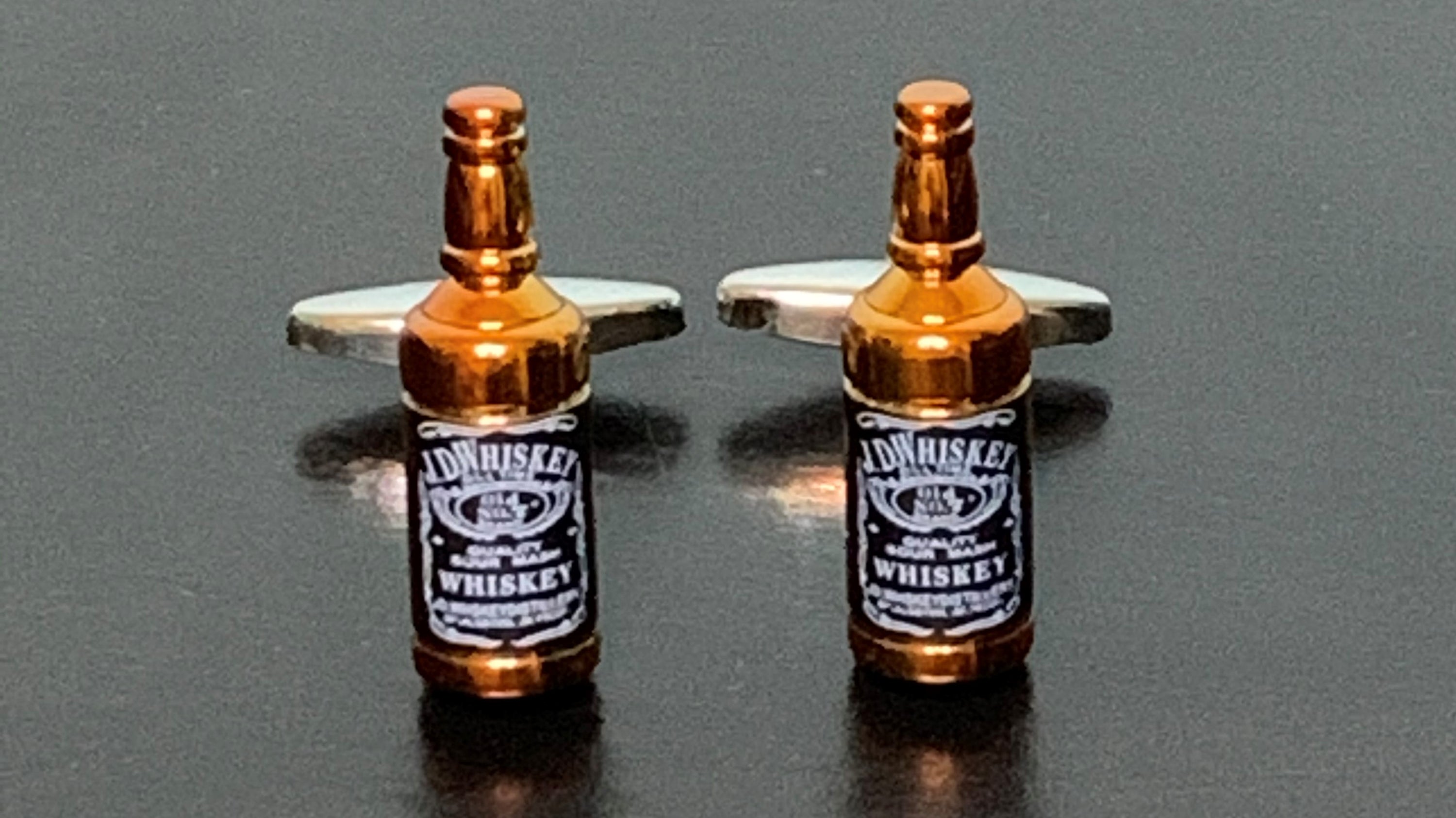 Elegant Gentleman Jack Rogue Whiskey cufflinks featuring a unique design, perfect for stylish gentlemen.