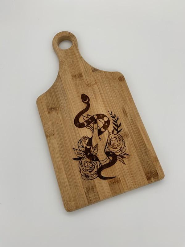 Bamboo paddle-shaped cutting board with a goddess theme, perfect for cooking and serving.