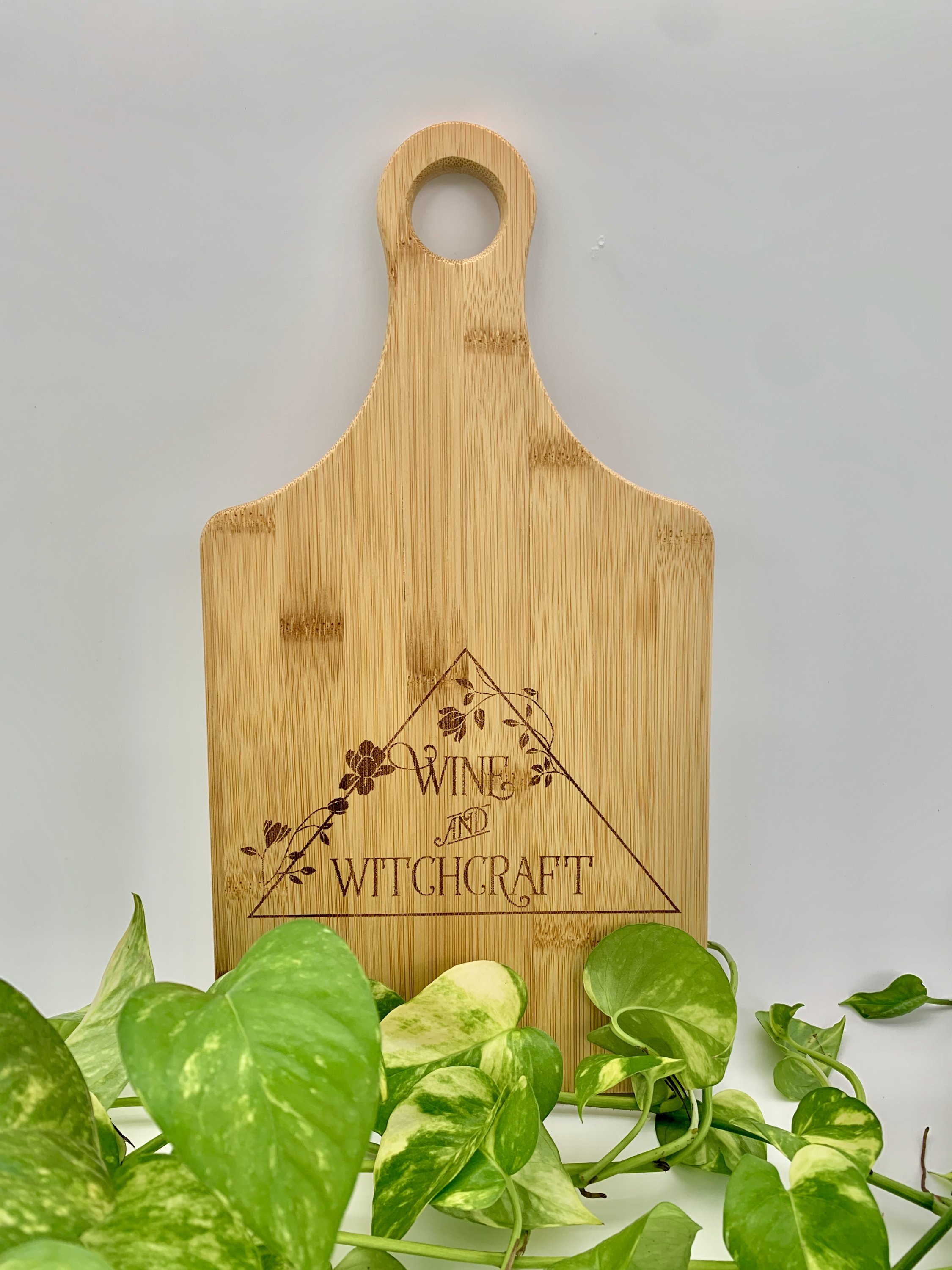 Bamboo paddle-shaped cutting board with a goddess theme, perfect for cooking and serving.