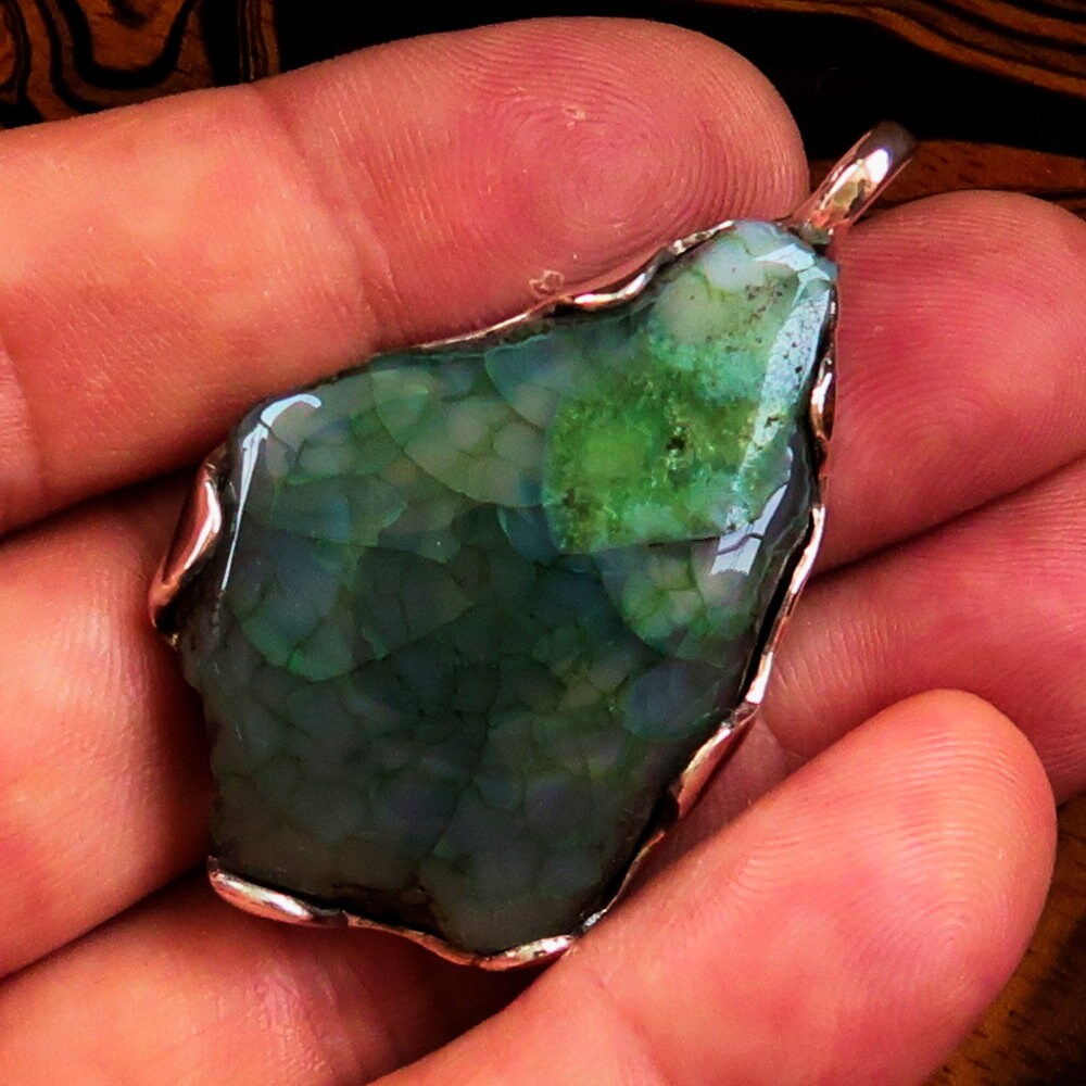 A beautiful Green Agate Amulet pendant set in Sterling Silver, showcasing a vibrant green druzy stone with intricate natural patterns.