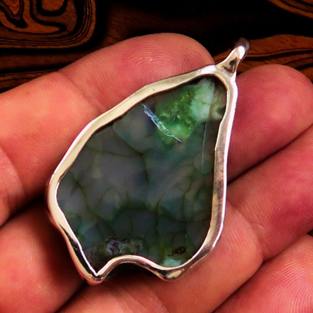 A beautiful Green Agate Amulet pendant set in Sterling Silver, showcasing a vibrant green druzy stone with intricate natural patterns.