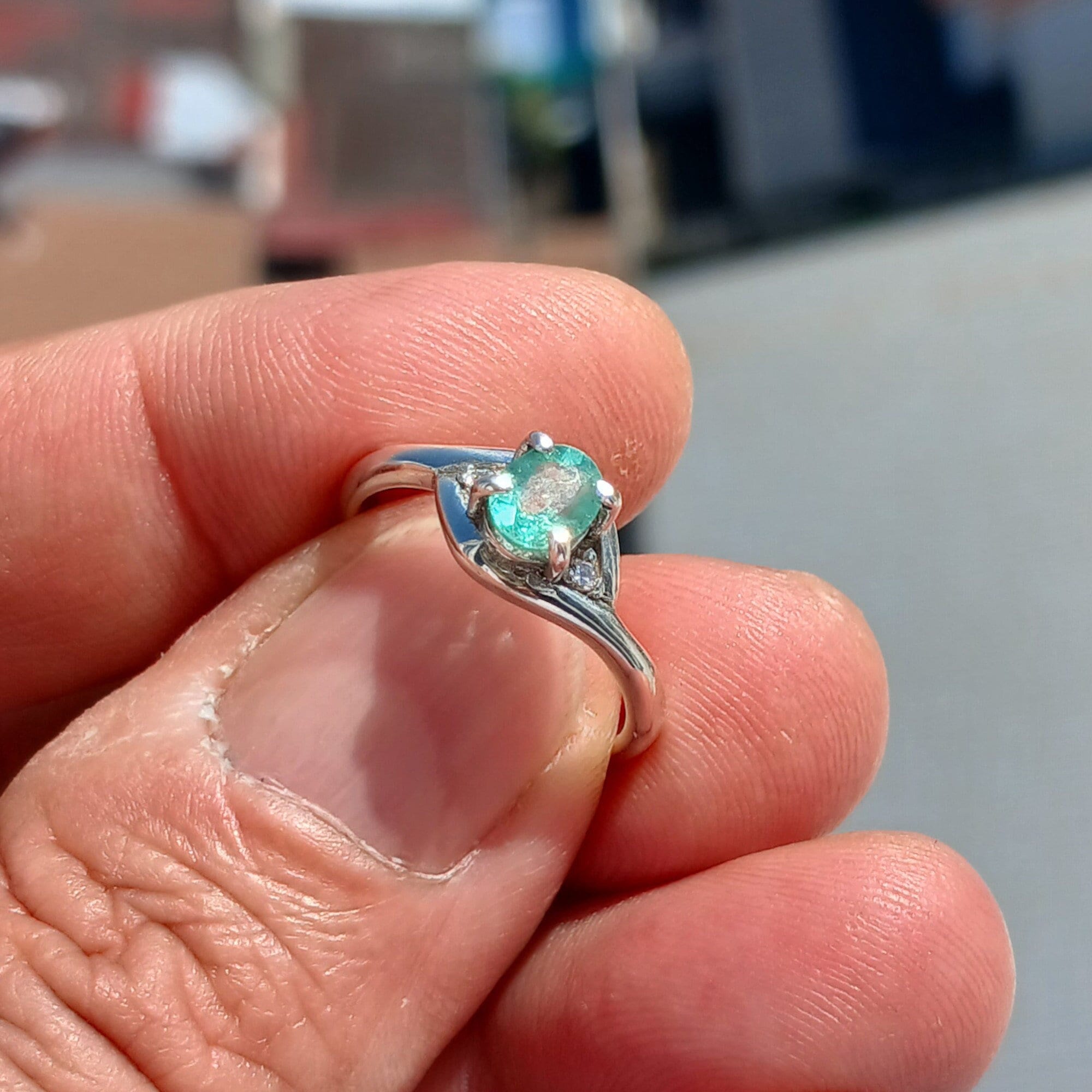 A stunning Green Emerald Ring featuring a natural oval cut emerald set in a polished sterling silver band with cubic zirconia accents.