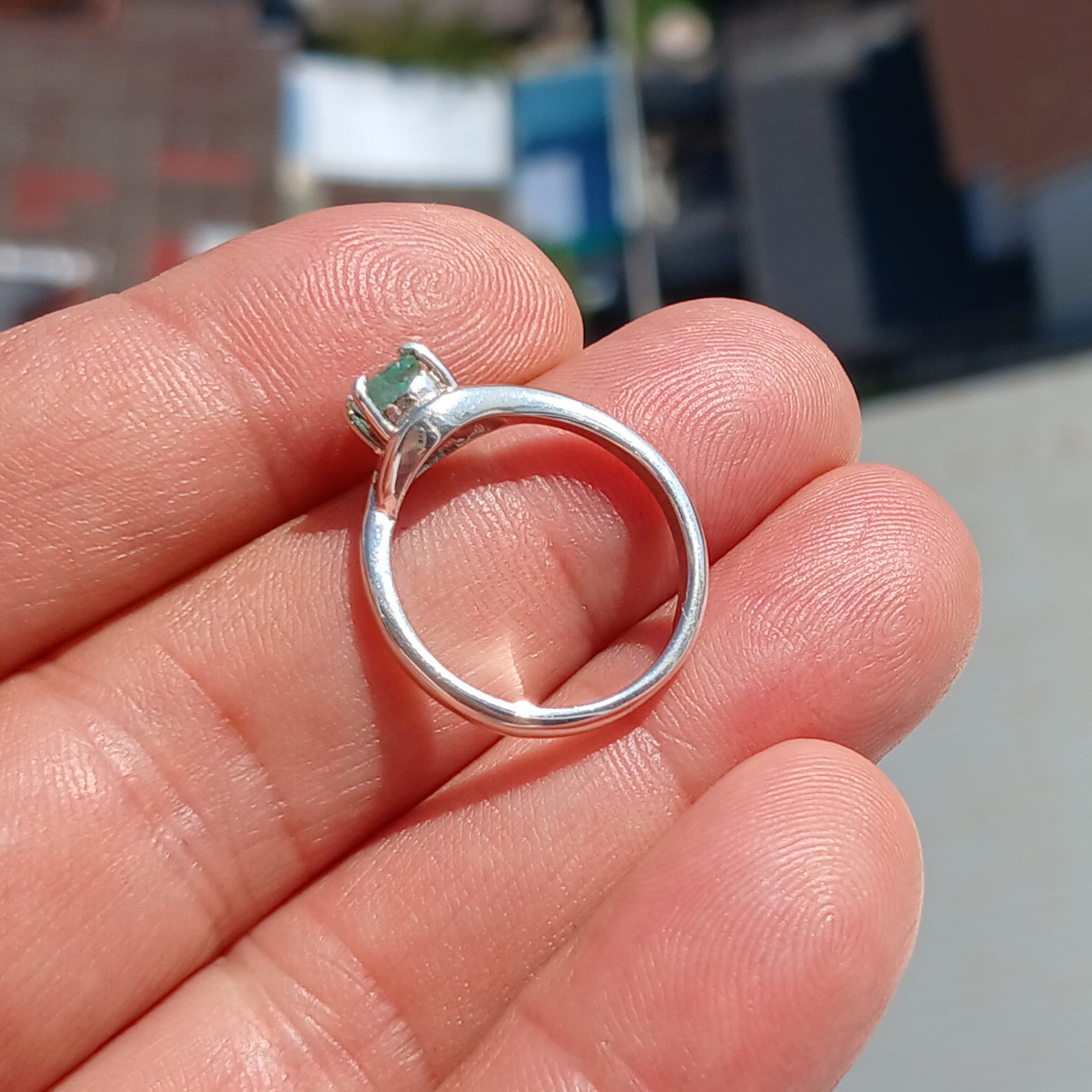 A stunning Green Emerald Ring featuring a natural oval cut emerald set in a polished sterling silver band with cubic zirconia accents.