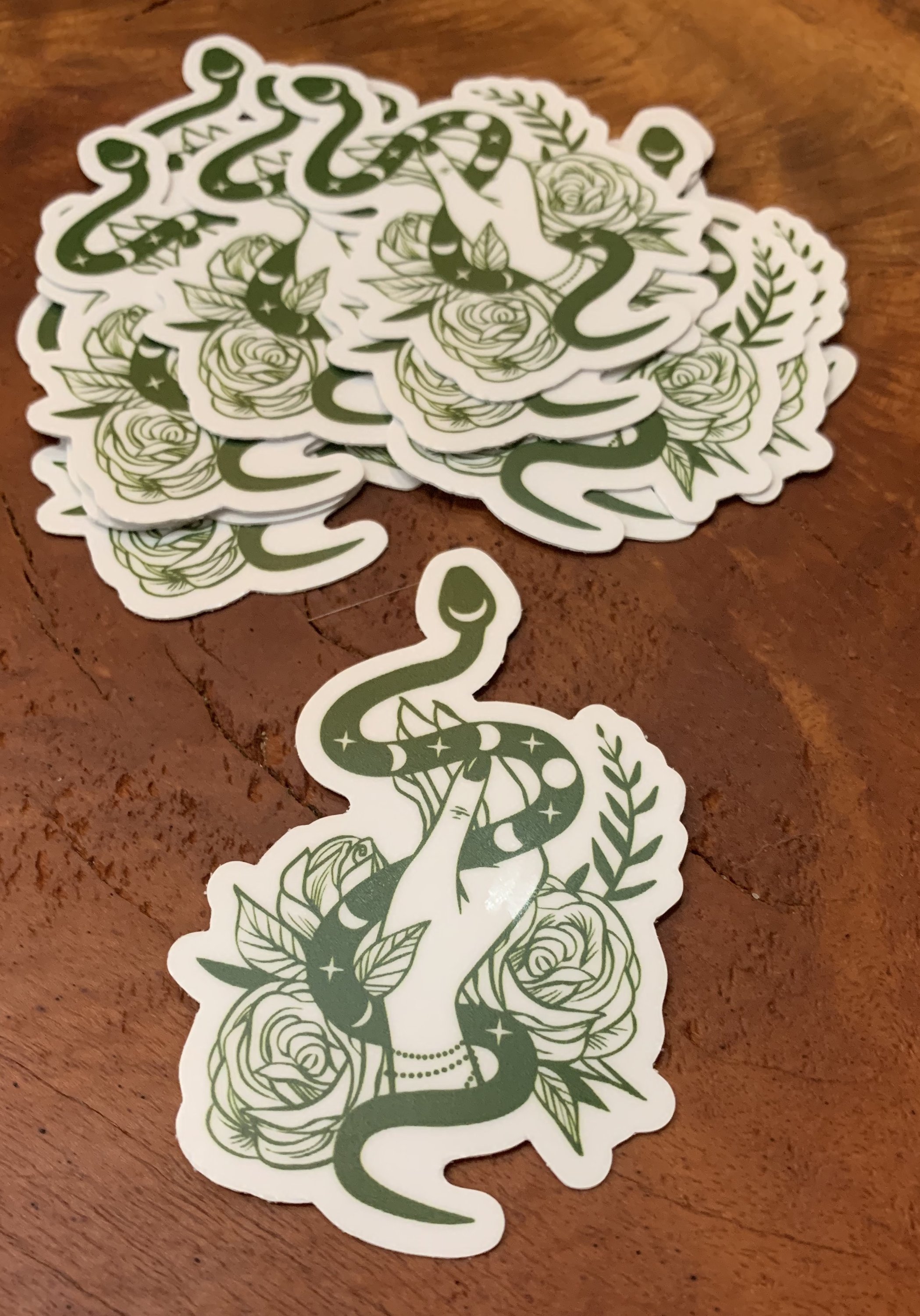 A vibrant Green Goddess Sticker featuring a serpent, rose, and moon cycle design, symbolizing transformation and beauty.