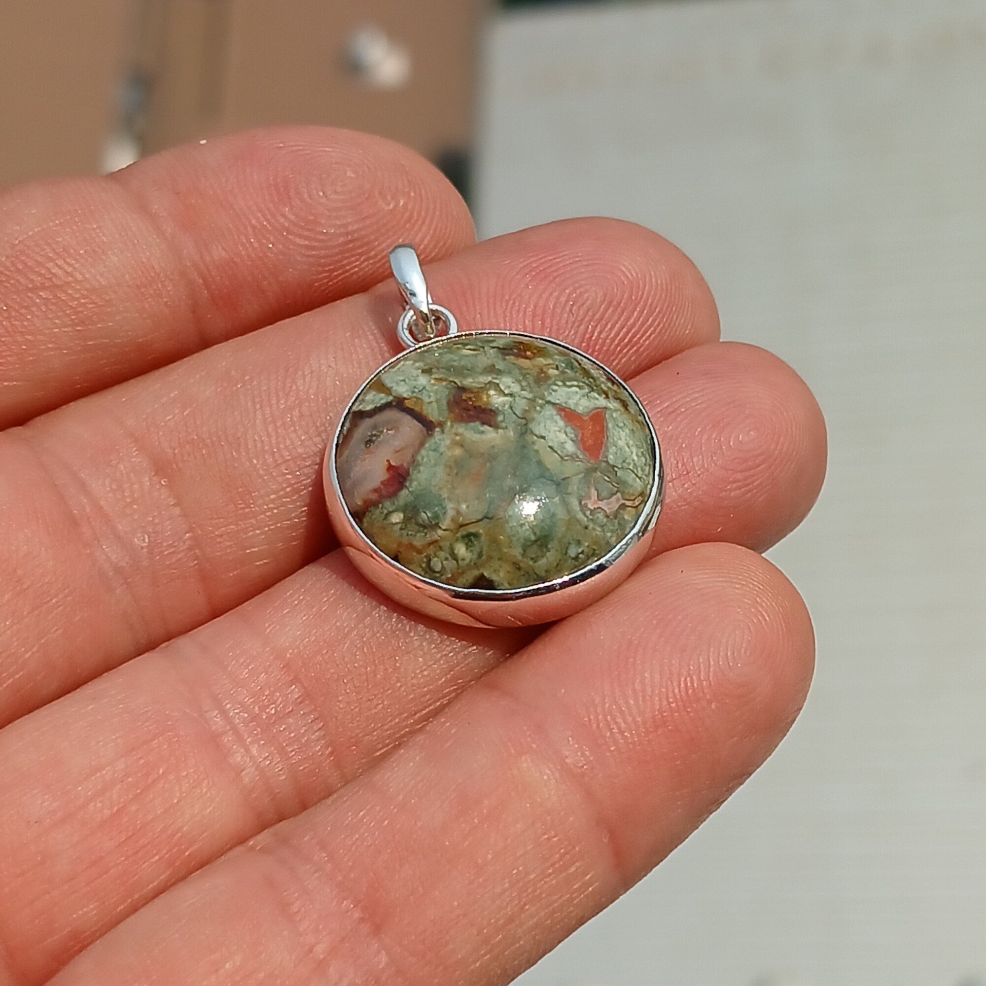 A beautiful round Green Jasper Pendant set in sterling silver, showcasing its minimalist design and vibrant color.