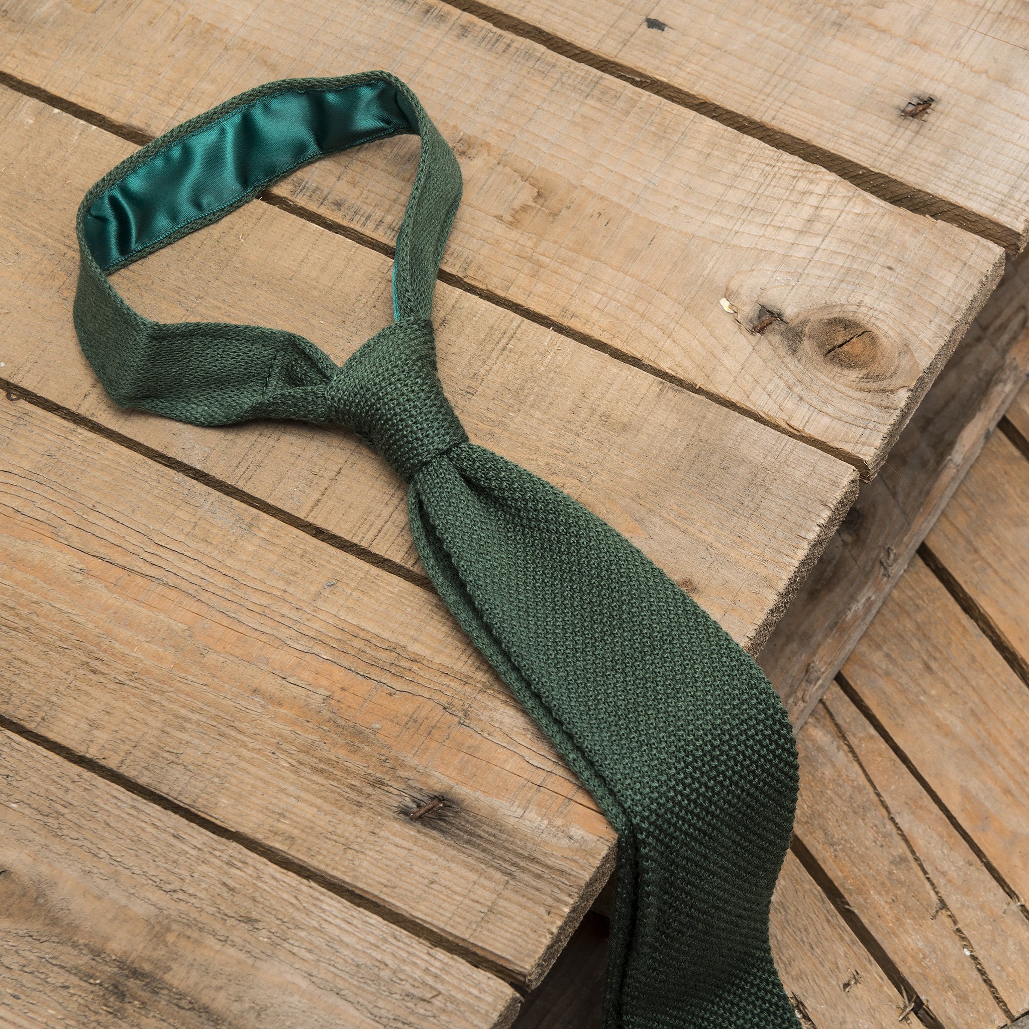 A stylish green knitted tie made of silk, featuring a pointed end and a 6cm width, perfect for formal occasions.