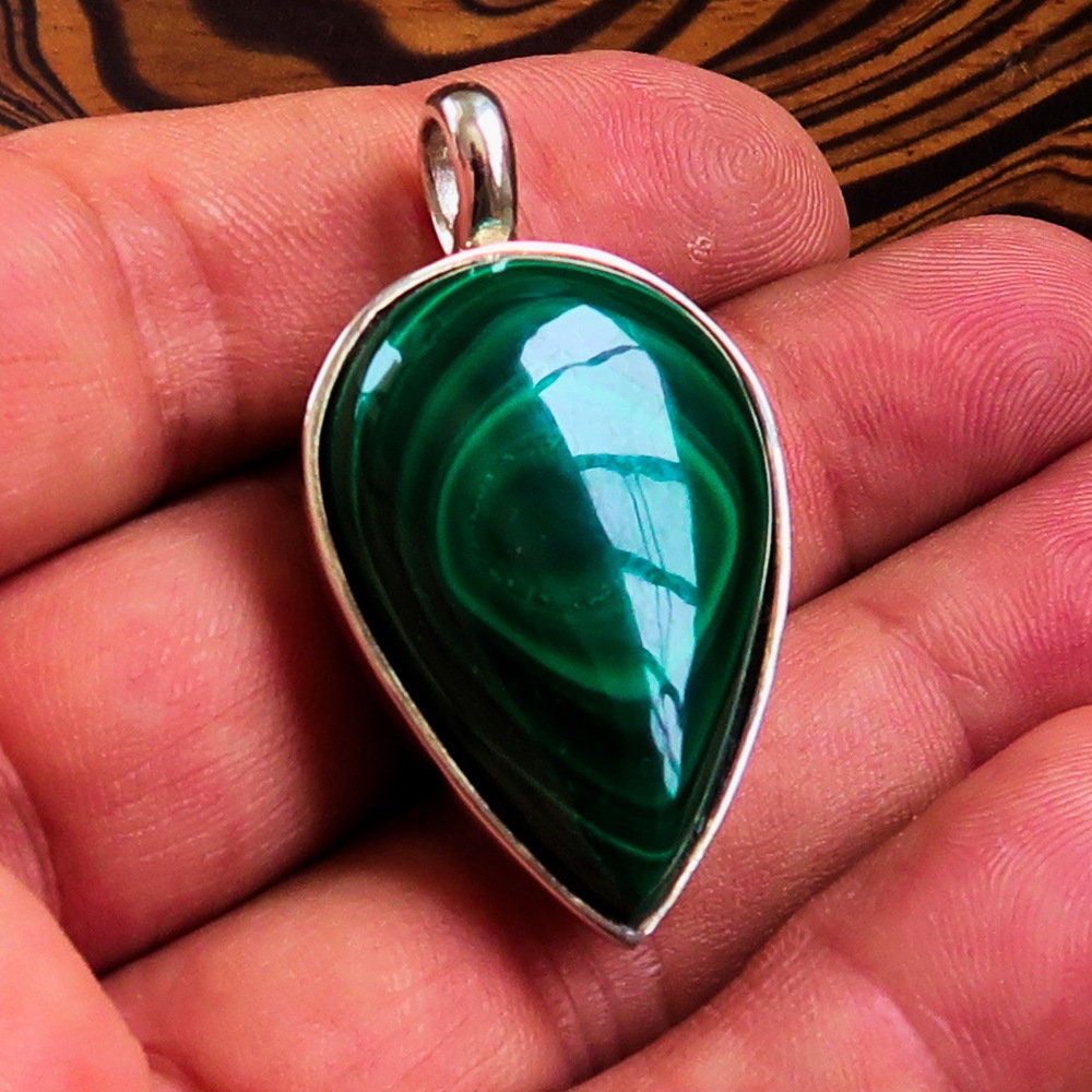 A stunning Green Malachite Pendant in pear shape, set in sterling silver, showcasing its vibrant green color and elegant design.