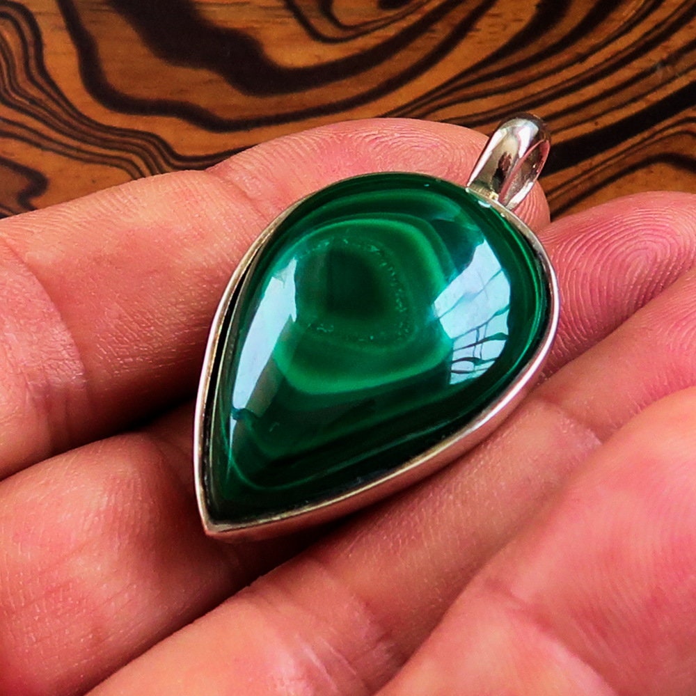 A stunning Green Malachite Pendant in pear shape, set in sterling silver, showcasing its vibrant green color and elegant design.