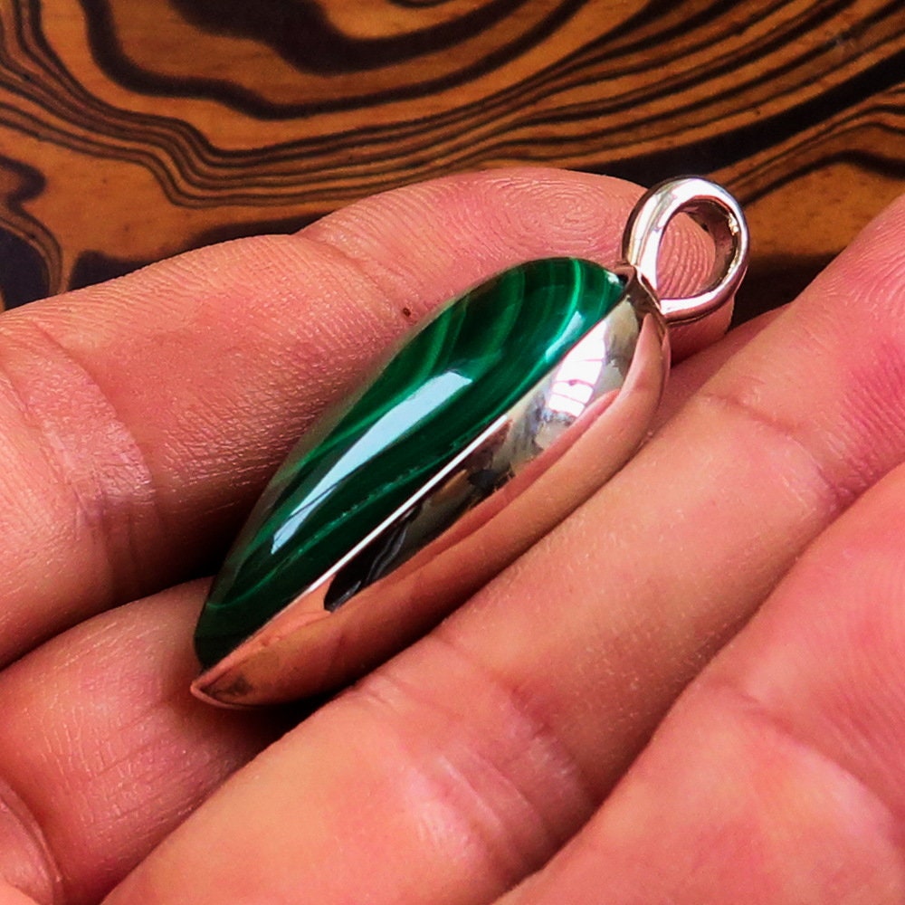 A stunning Green Malachite Pendant in pear shape, set in sterling silver, showcasing its vibrant green color and elegant design.