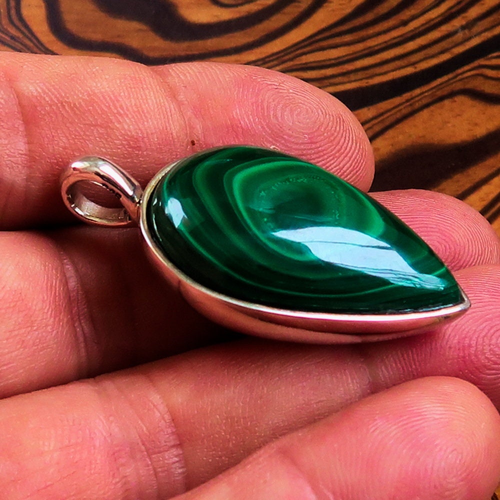 A stunning Green Malachite Pendant in pear shape, set in sterling silver, showcasing its vibrant green color and elegant design.