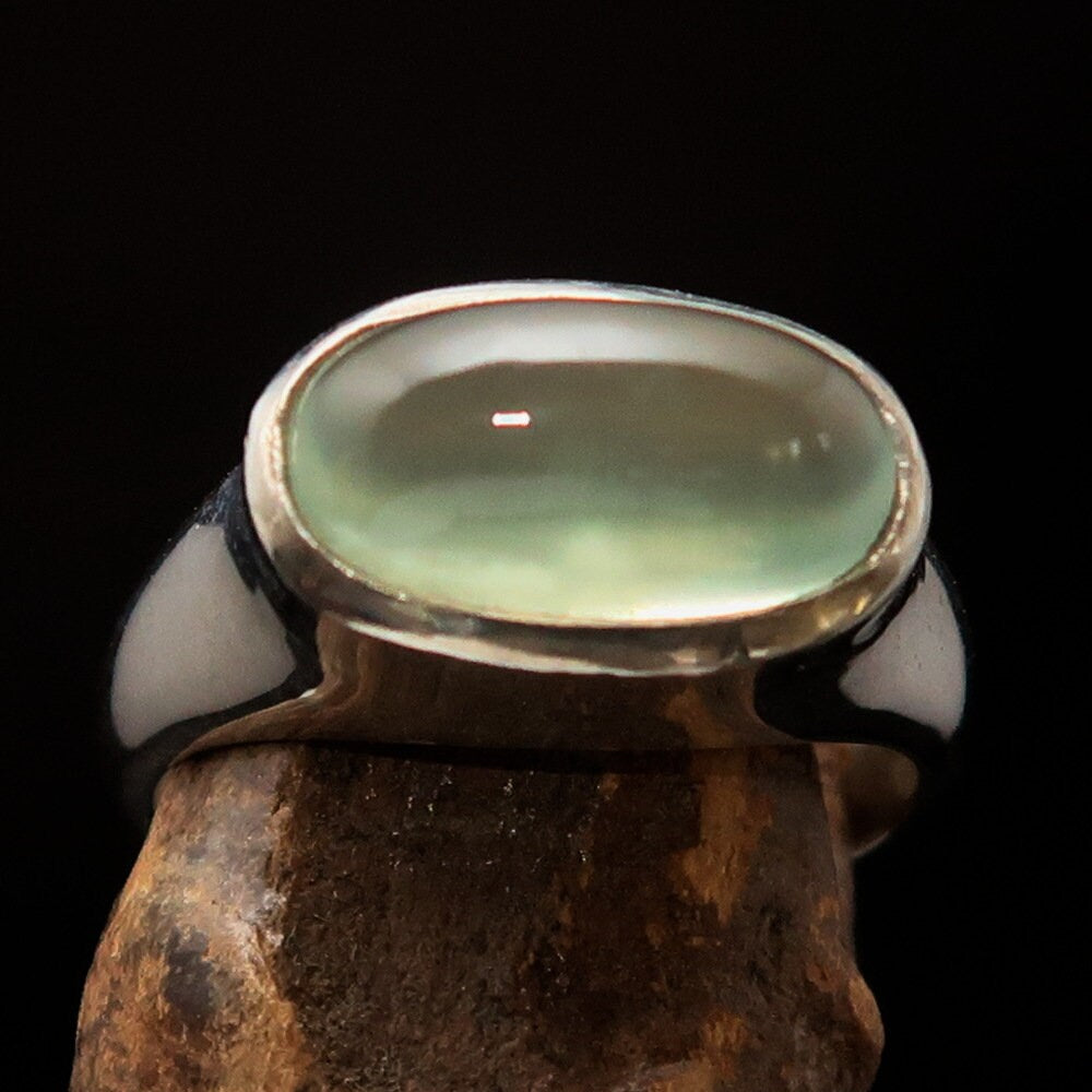 Handmade sterling silver solitaire ring featuring an oval green Prehnite stone, showcasing a polished finish and minimalist design.