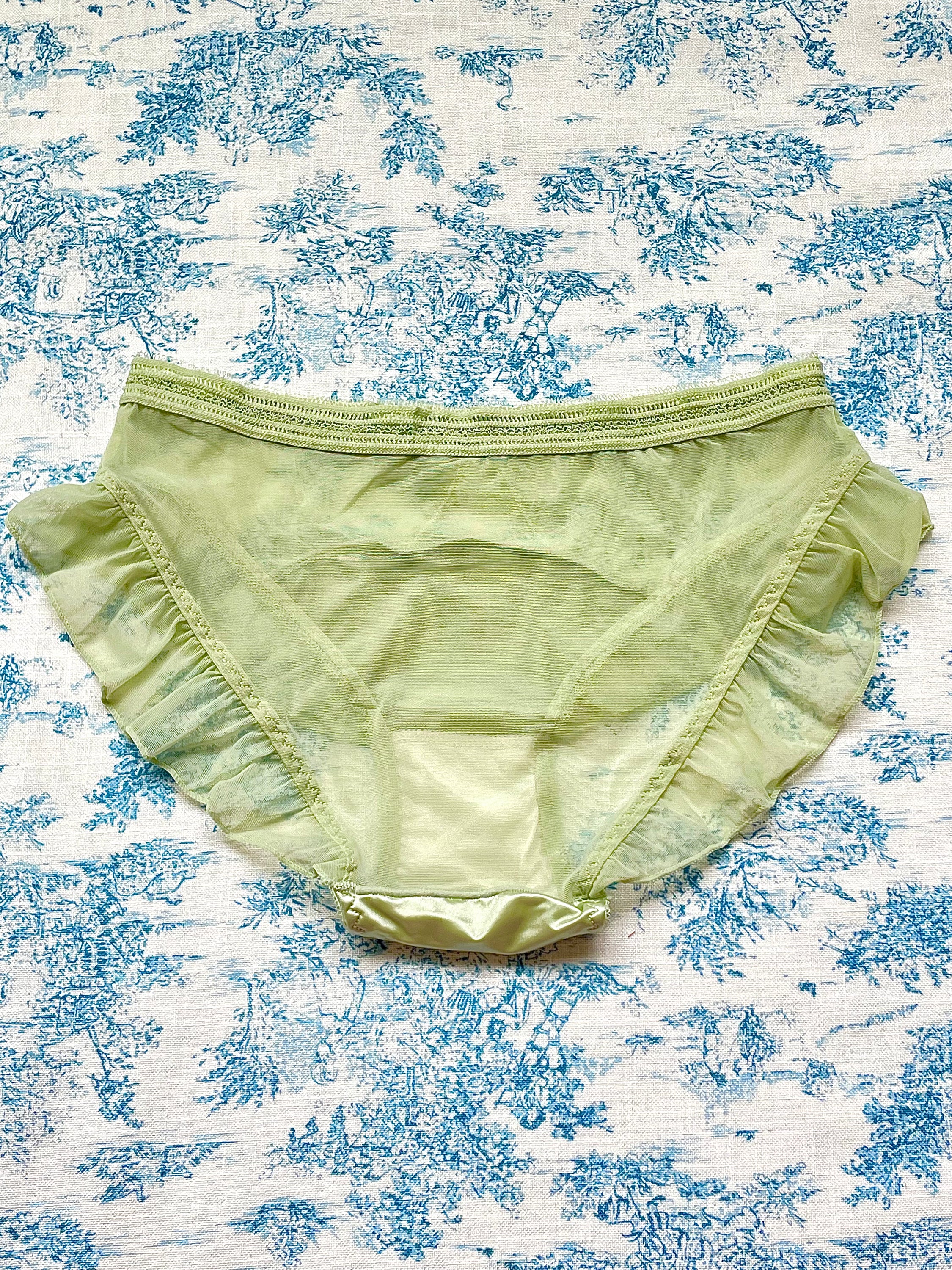 Elegant green satin and mesh panty with lace trim and bow detail, showcasing its luxurious design and comfortable cotton lining.