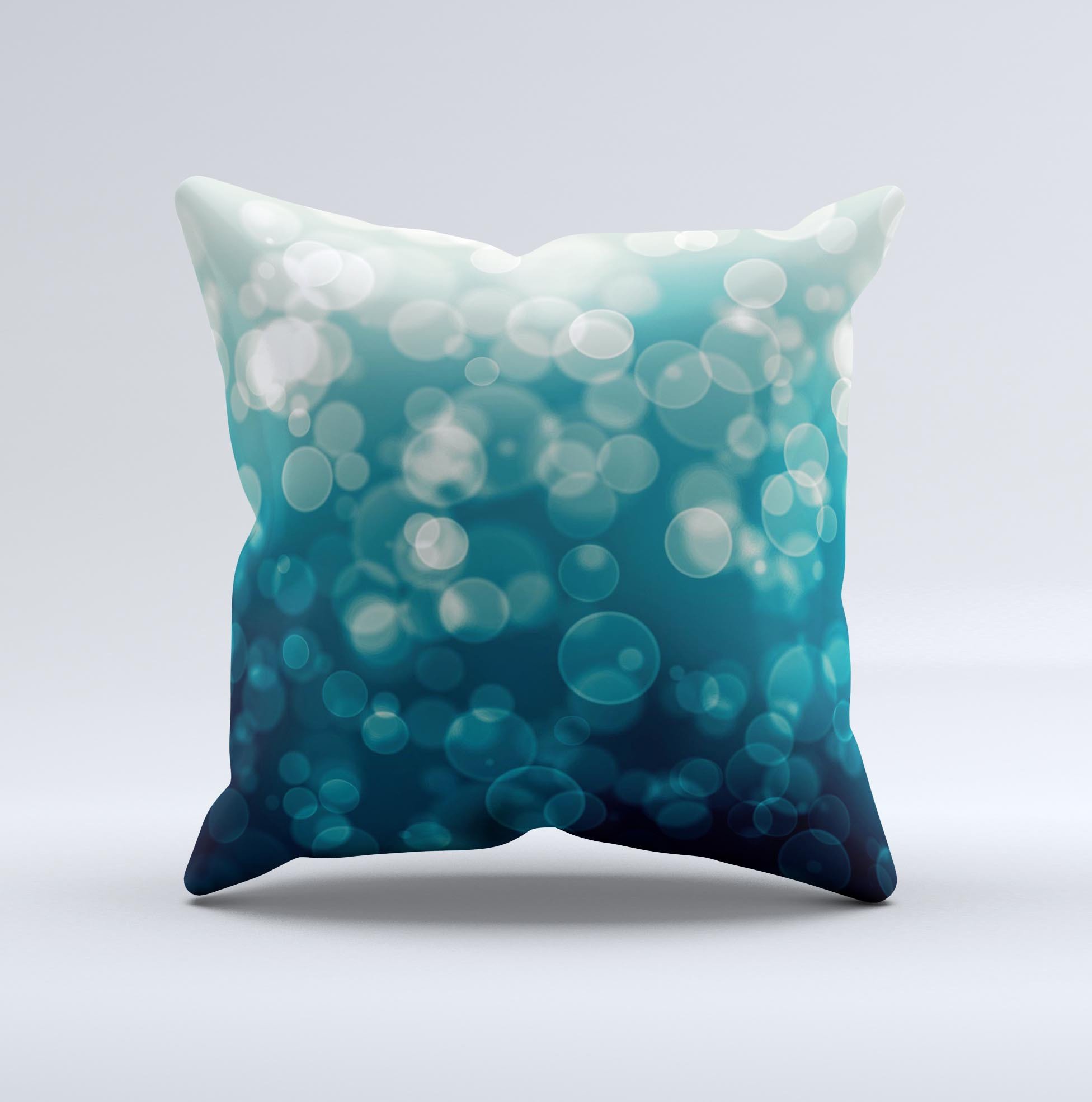 A decorative throw pillow featuring green unfocused orbs of light design, handcrafted in Virginia with a high thread count fabric and plush filling.