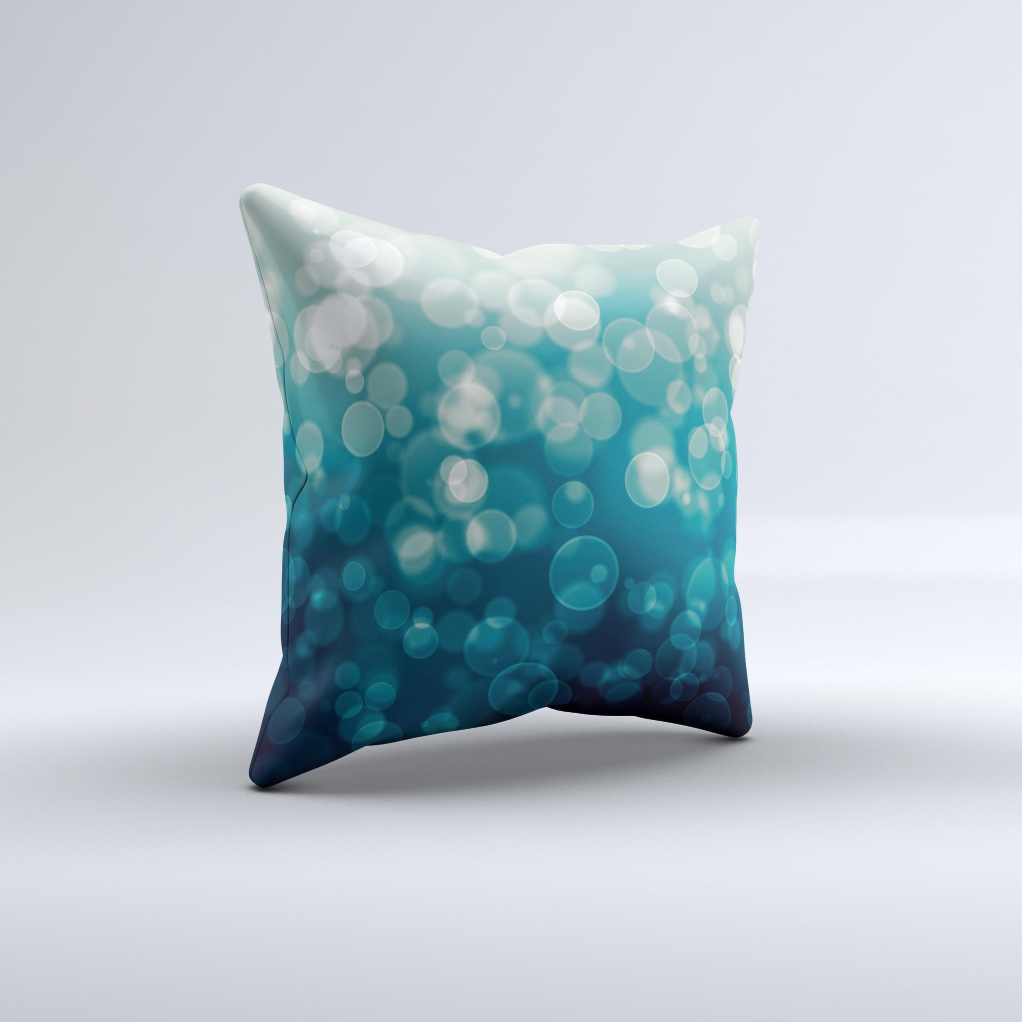 A decorative throw pillow featuring green unfocused orbs of light design, handcrafted in Virginia with a high thread count fabric and plush filling.