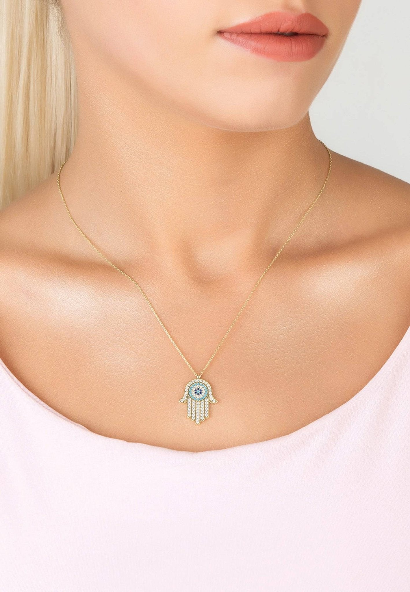 Hamsa Hand With Evil Eye Pendant Necklace in gold, featuring sparkling white and blue zircons.