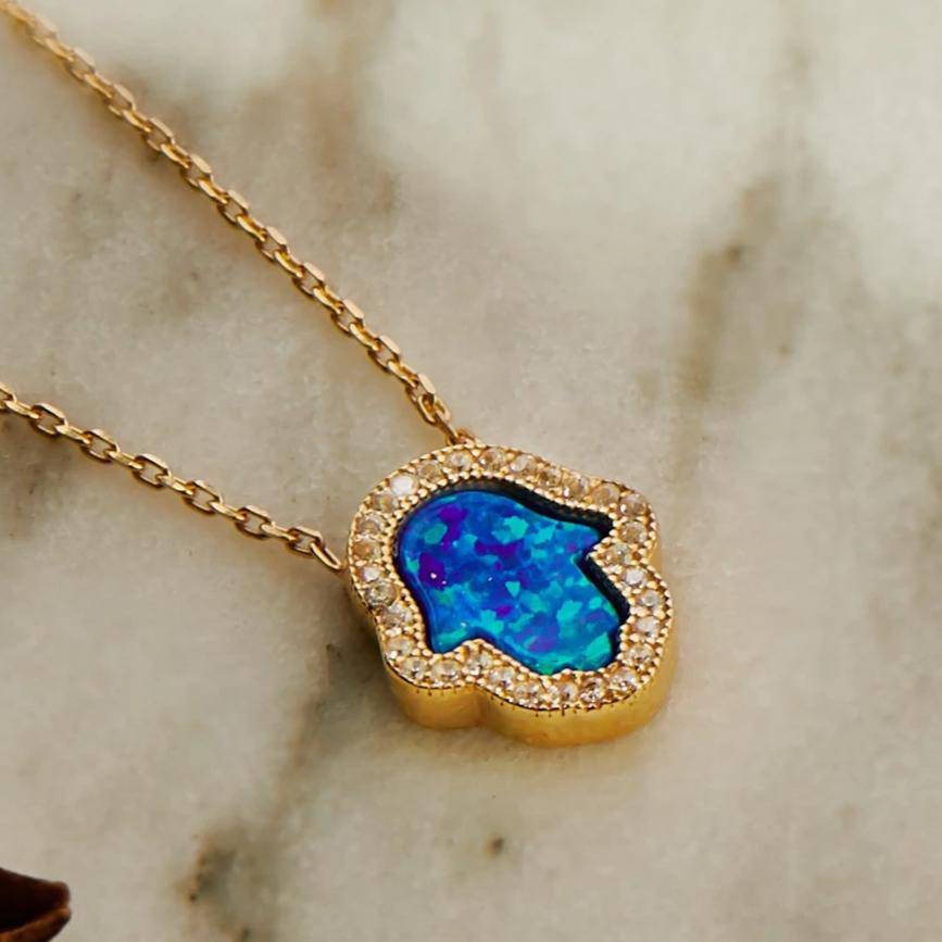 Hamsa Opalite Turquoise Blue Necklace Gold featuring an iridescent opalite gemstone and sparkling zirconia on a 925 sterling silver chain.