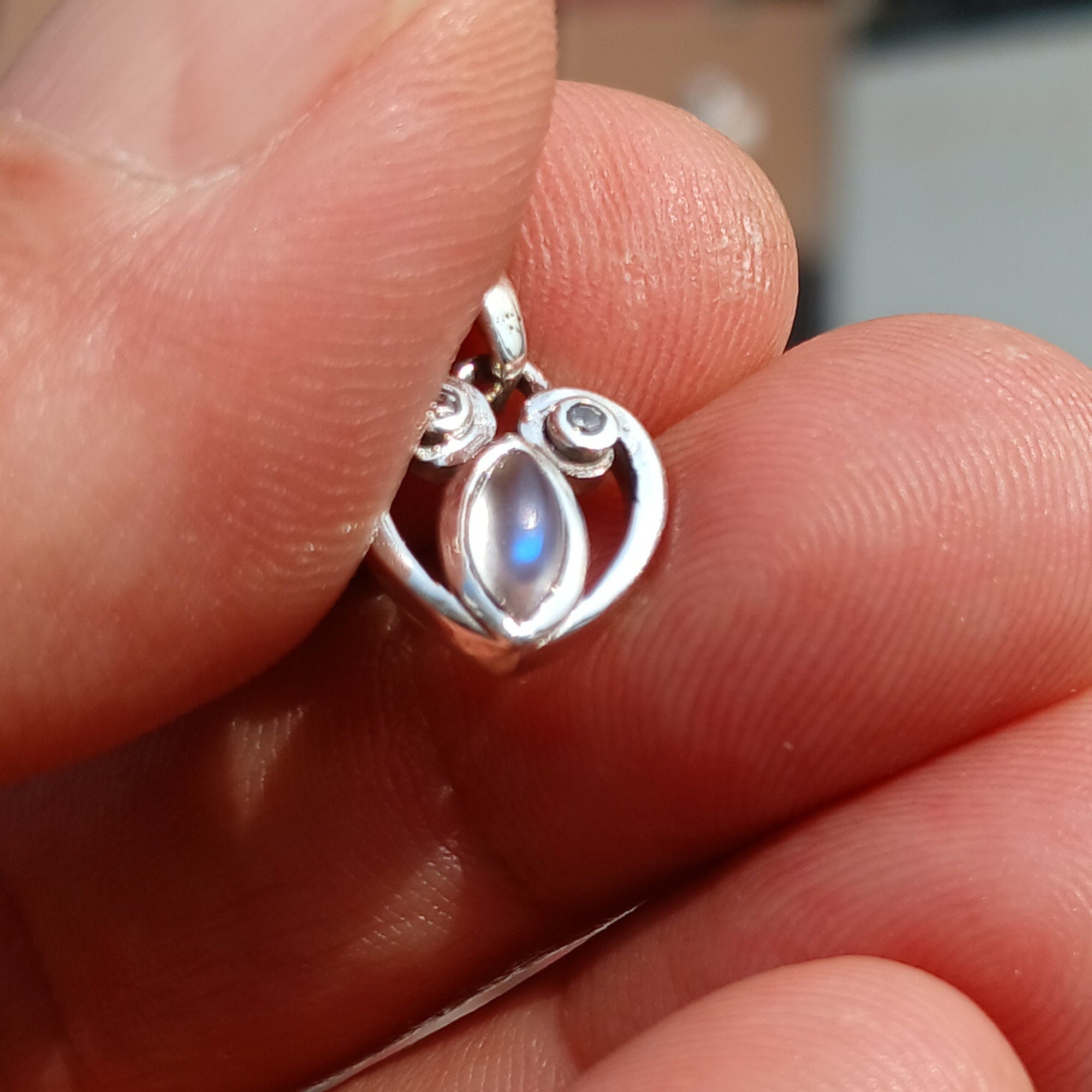 Sterling silver heart pendant with Ceylon moonstone, showcasing its elegant design and shimmering gemstone.