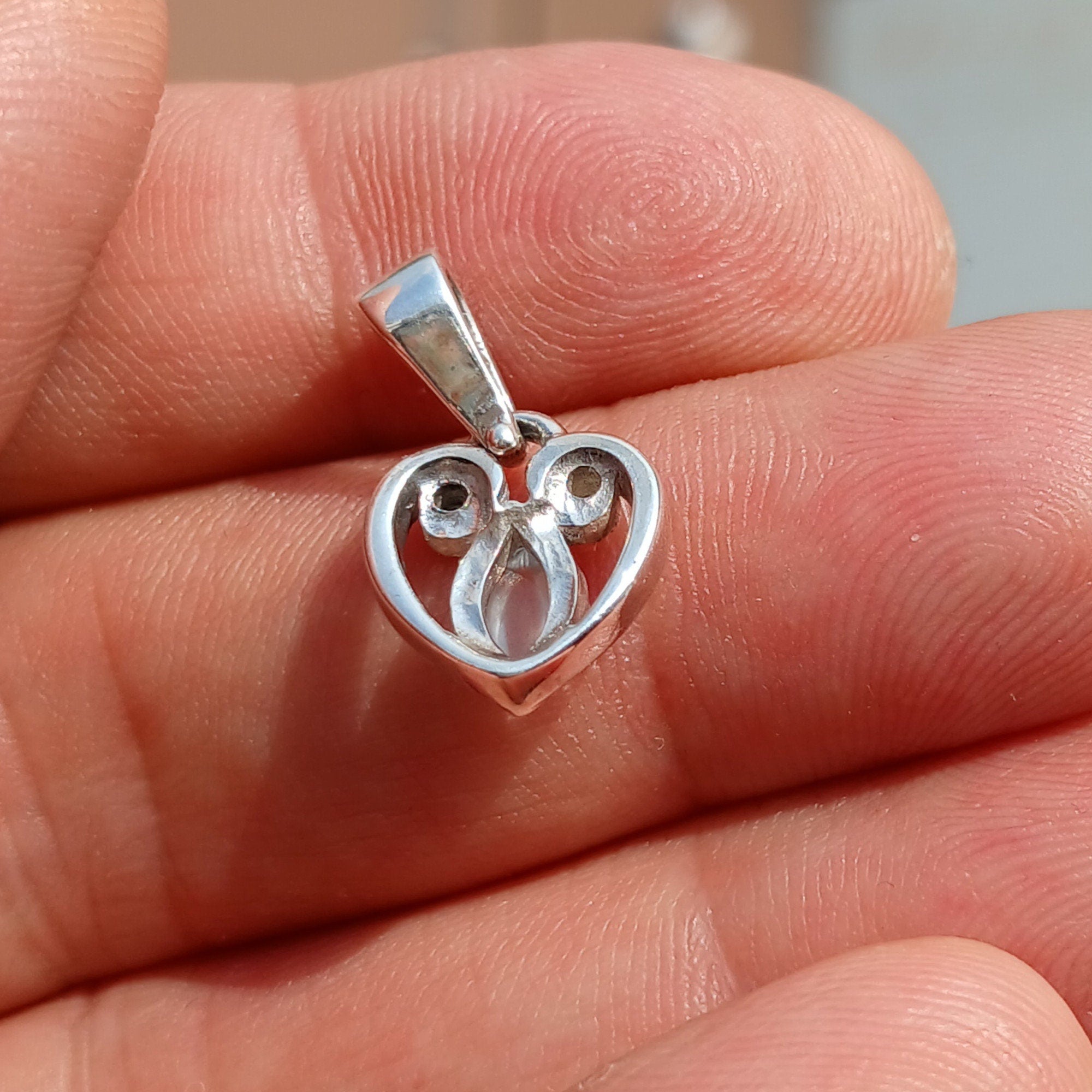 Sterling silver heart pendant with Ceylon moonstone, showcasing its elegant design and shimmering gemstone.