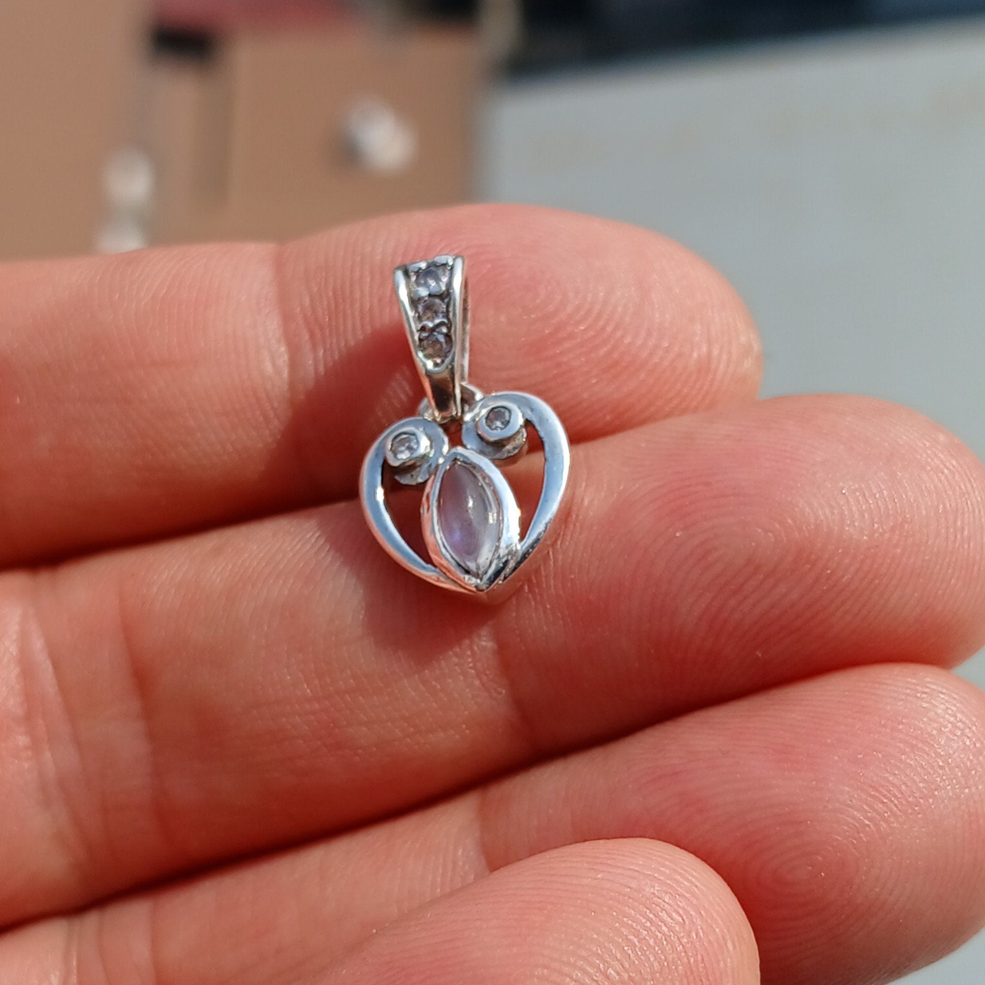 Sterling silver heart pendant with Ceylon moonstone, showcasing its elegant design and shimmering gemstone.