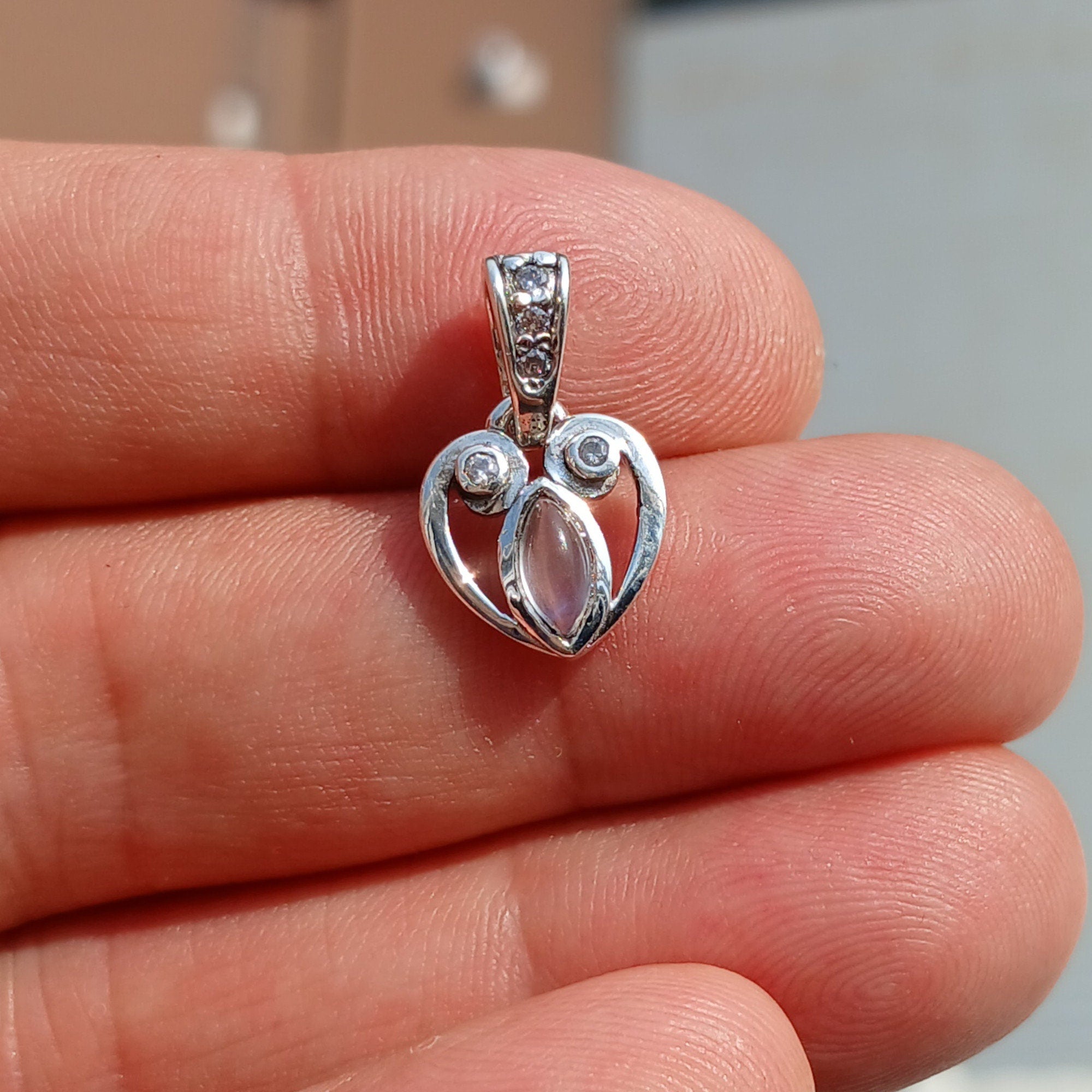 Sterling silver heart pendant with Ceylon moonstone, showcasing its elegant design and shimmering gemstone.