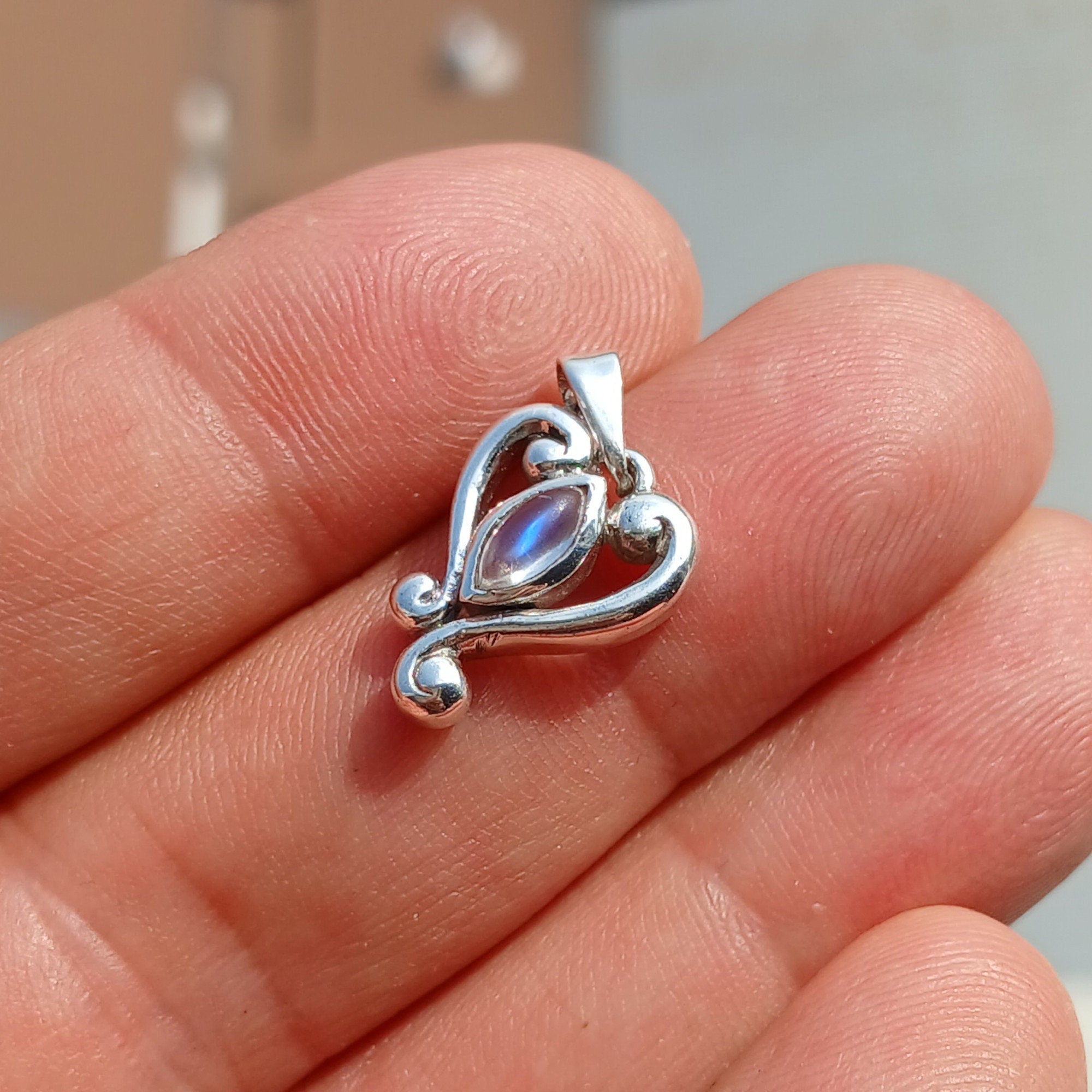 A beautiful Heart Pendant made of 925 Sterling Silver featuring a marquise Ceylon Moonstone cabochon, showcasing elegance and charm.