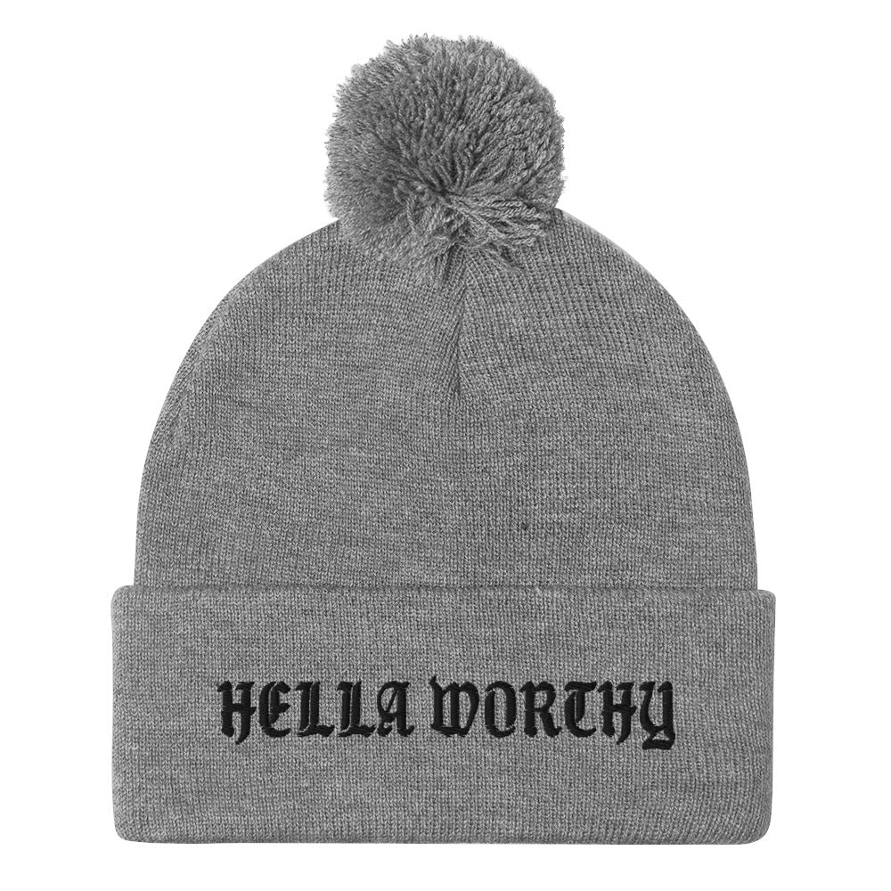 Hella Worthy Pom-Pom Beanie in a classic embroidered design with a playful pom-pom on top, showcasing its warm and stylish features.