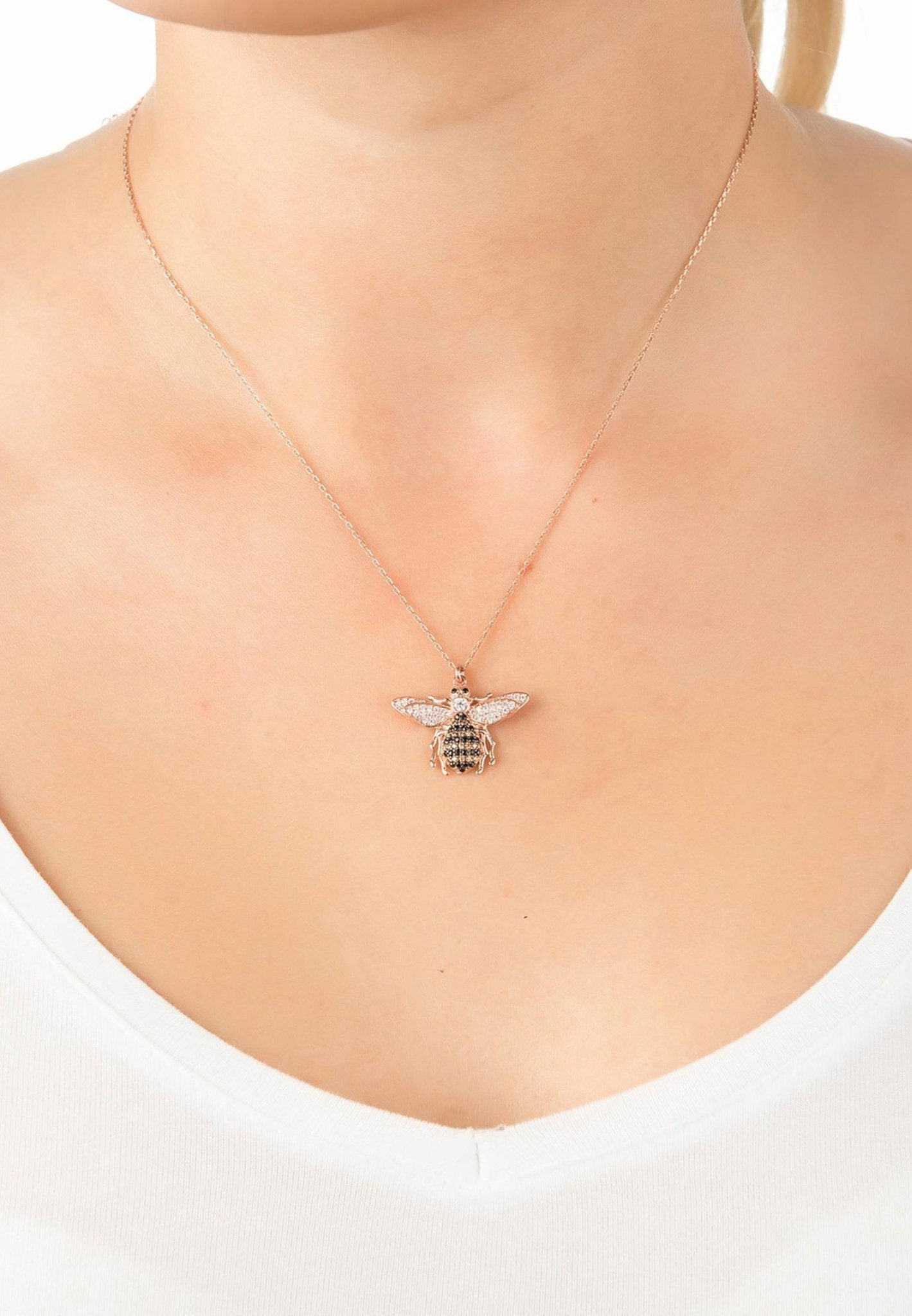 A beautiful gold honey bee pendant necklace, handcrafted from sterling silver and adorned with sparkling zircons, showcasing a playful bee charm.