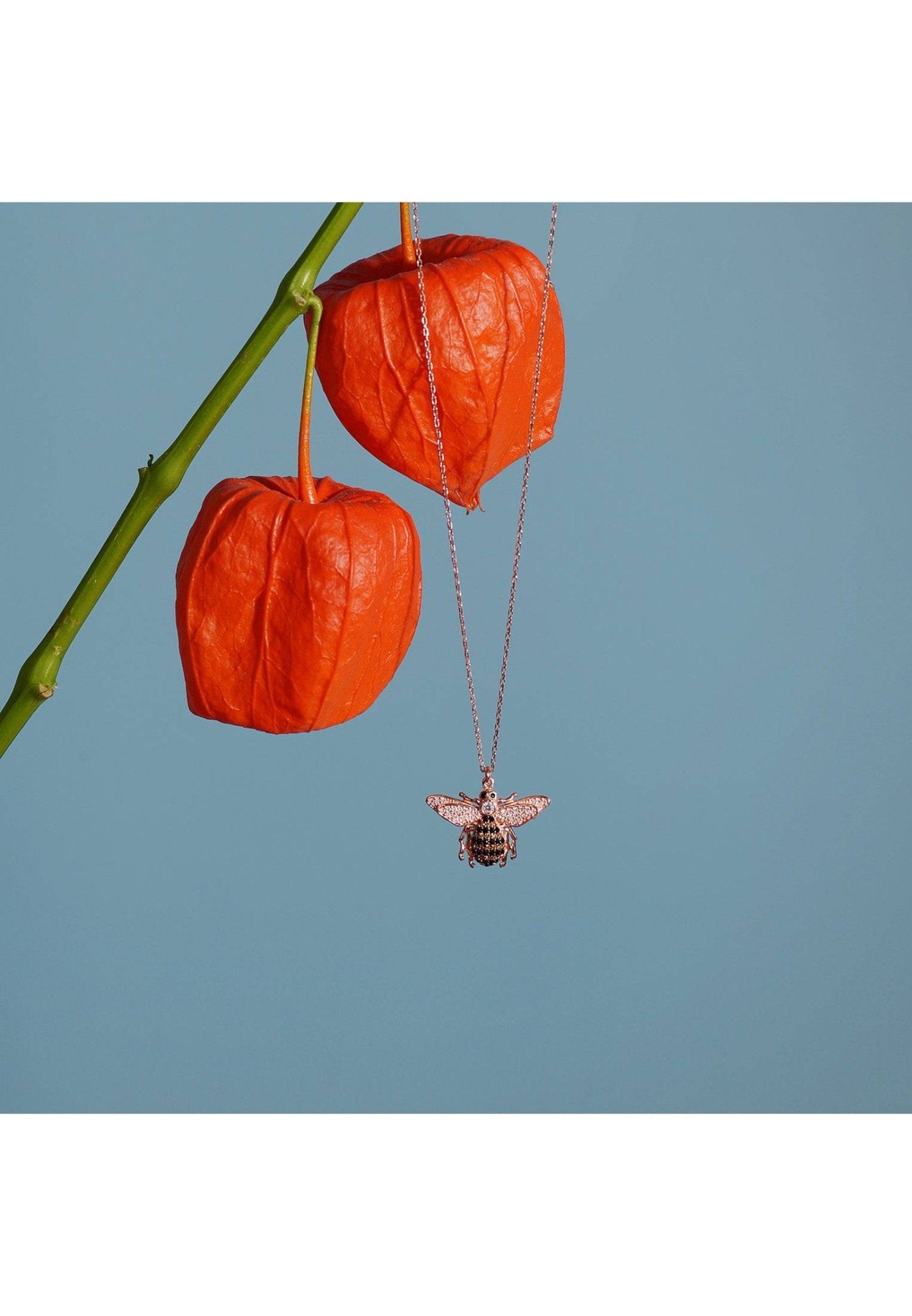 A beautiful gold honey bee pendant necklace, handcrafted from sterling silver and adorned with sparkling zircons, showcasing a playful bee charm.