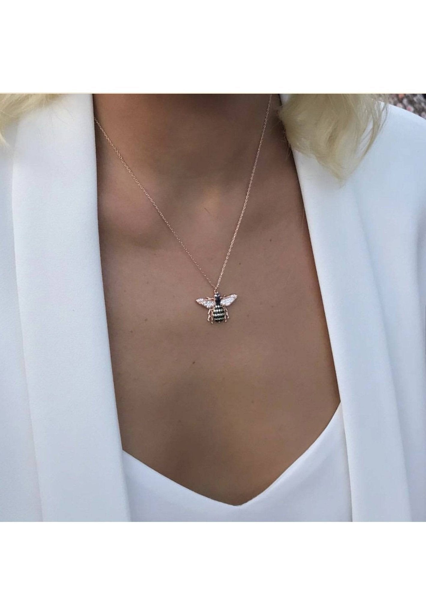 A beautiful rose gold honey bee pendant necklace featuring sparkling white, champagne, and black zircons, elegantly displayed on a white background.