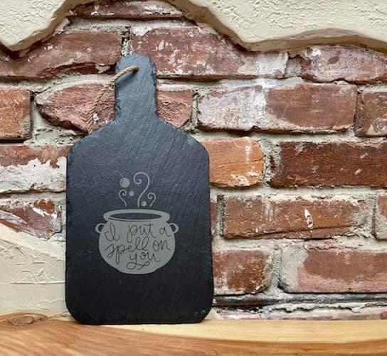 I Put a Spell on You Serving Board made of unique slate stone, featuring a rustic design and rope for hanging.