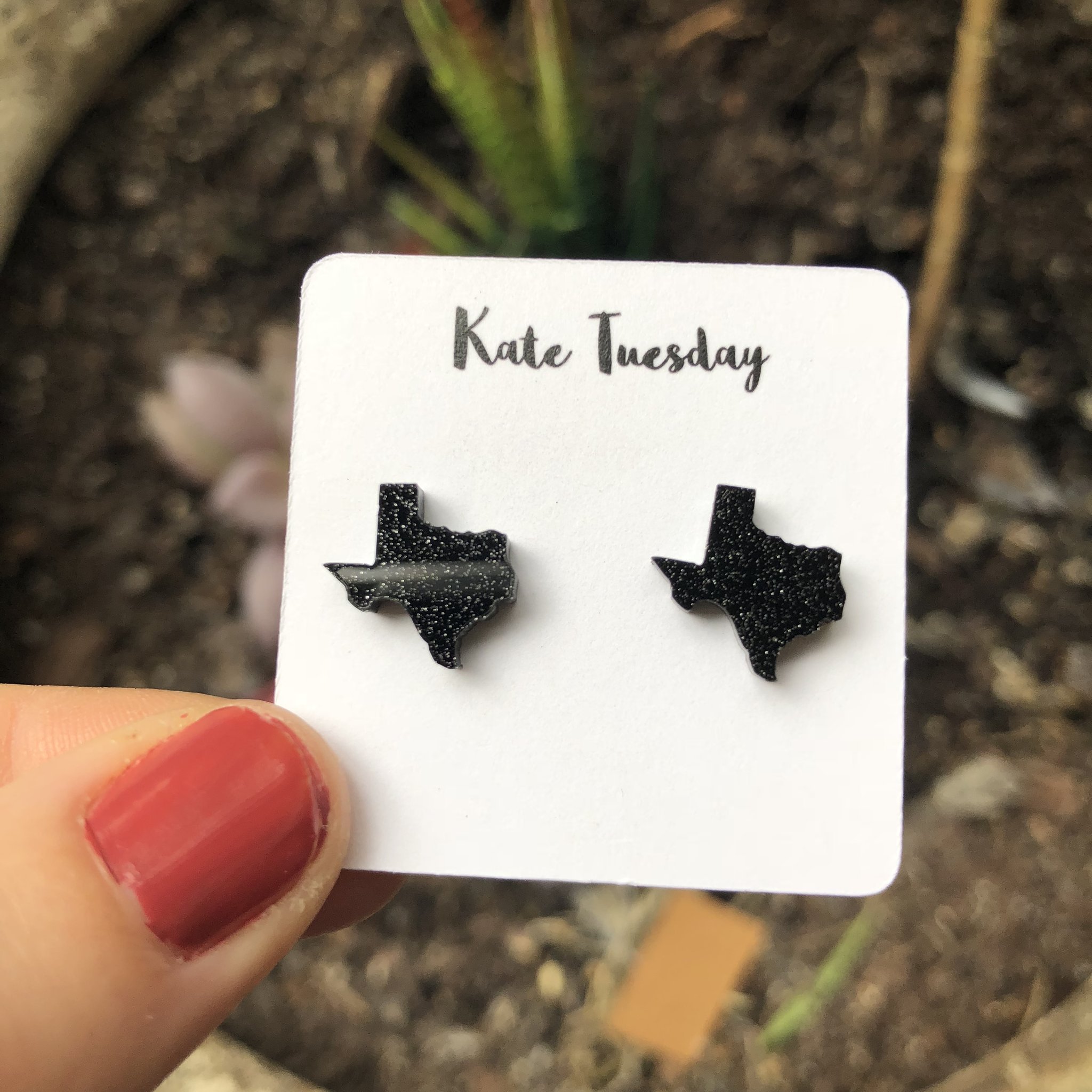 A pack of four Idaho Glitter State Stud Earrings featuring sparkly acrylic designs, showcasing their vibrant colors and lightweight construction.