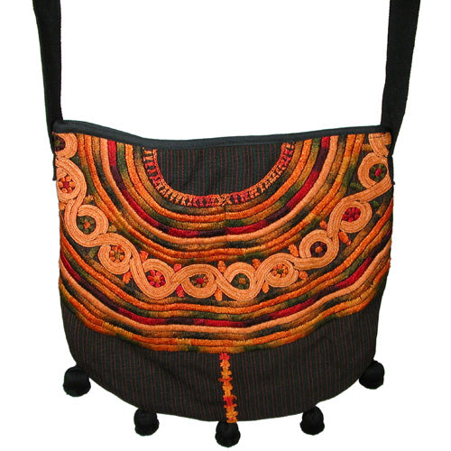 Joyabaj Shoulder Purse handmade from recycled huipils, featuring vibrant colors and ball fringe, perfect for everyday use.