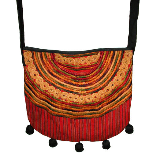 Joyabaj Shoulder Purse handmade from recycled huipils, featuring vibrant colors and ball fringe, perfect for everyday use.