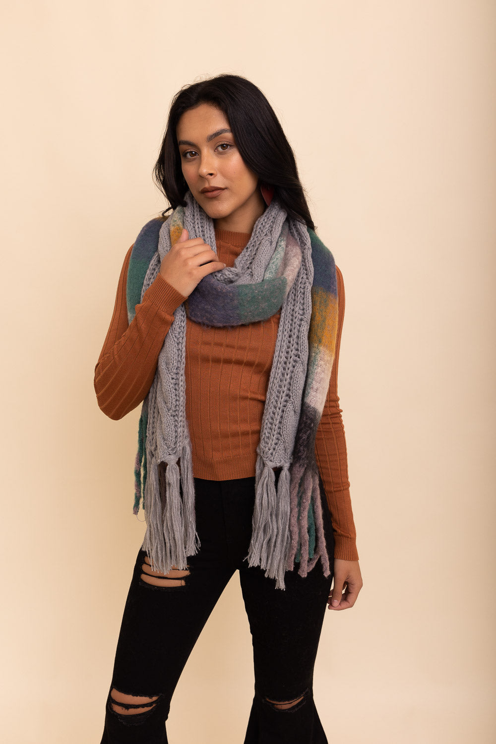 A stylish knit blend scarf with tassel trim, perfect for cold weather outfits, showcasing its soft texture and trendy design.